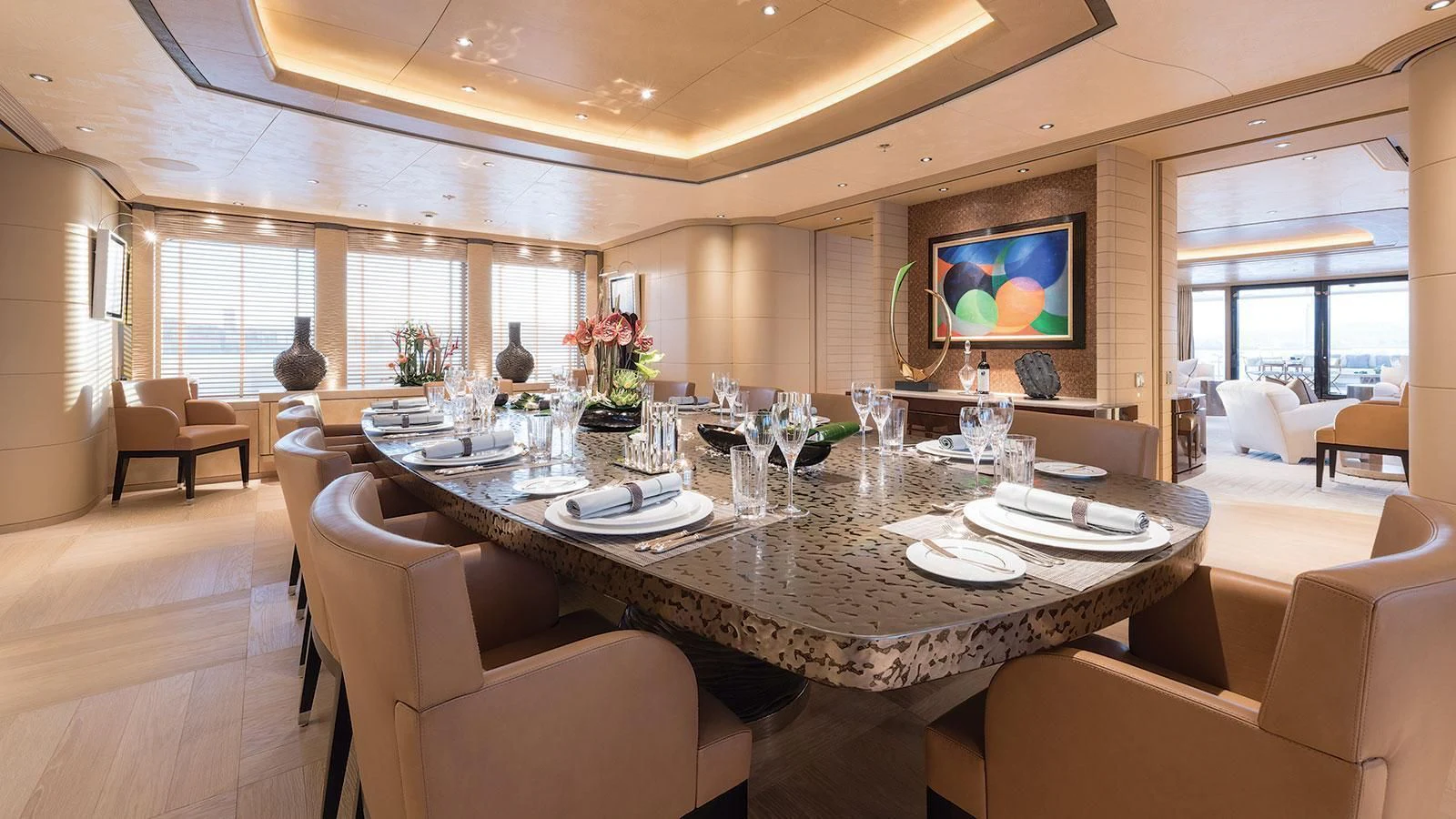 a large dining table with white plates and chairs aboard ROMEA Yacht for Sale