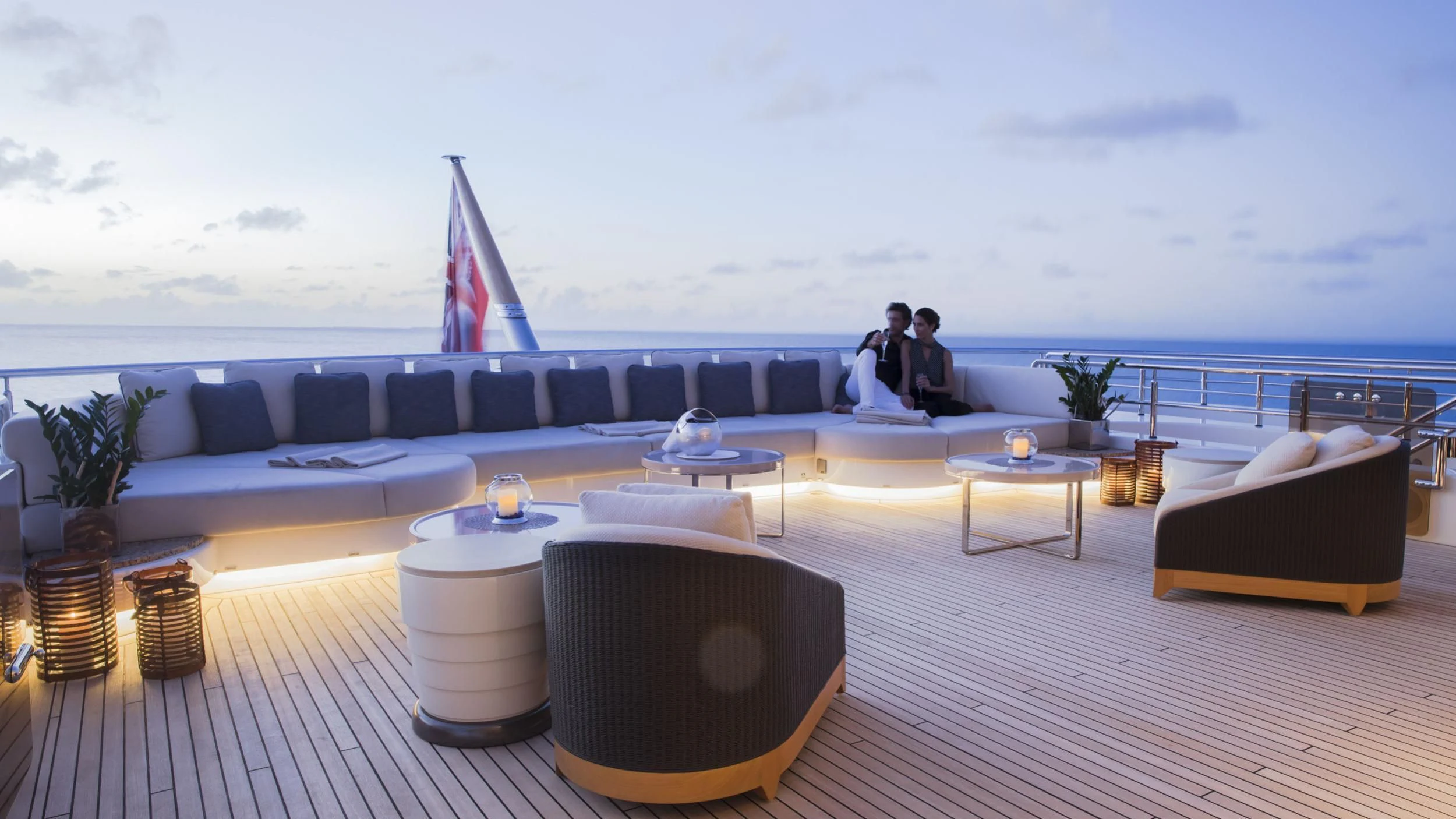 a couple sitting on a couch in front of a large body of water aboard ROMEA Yacht for Sale