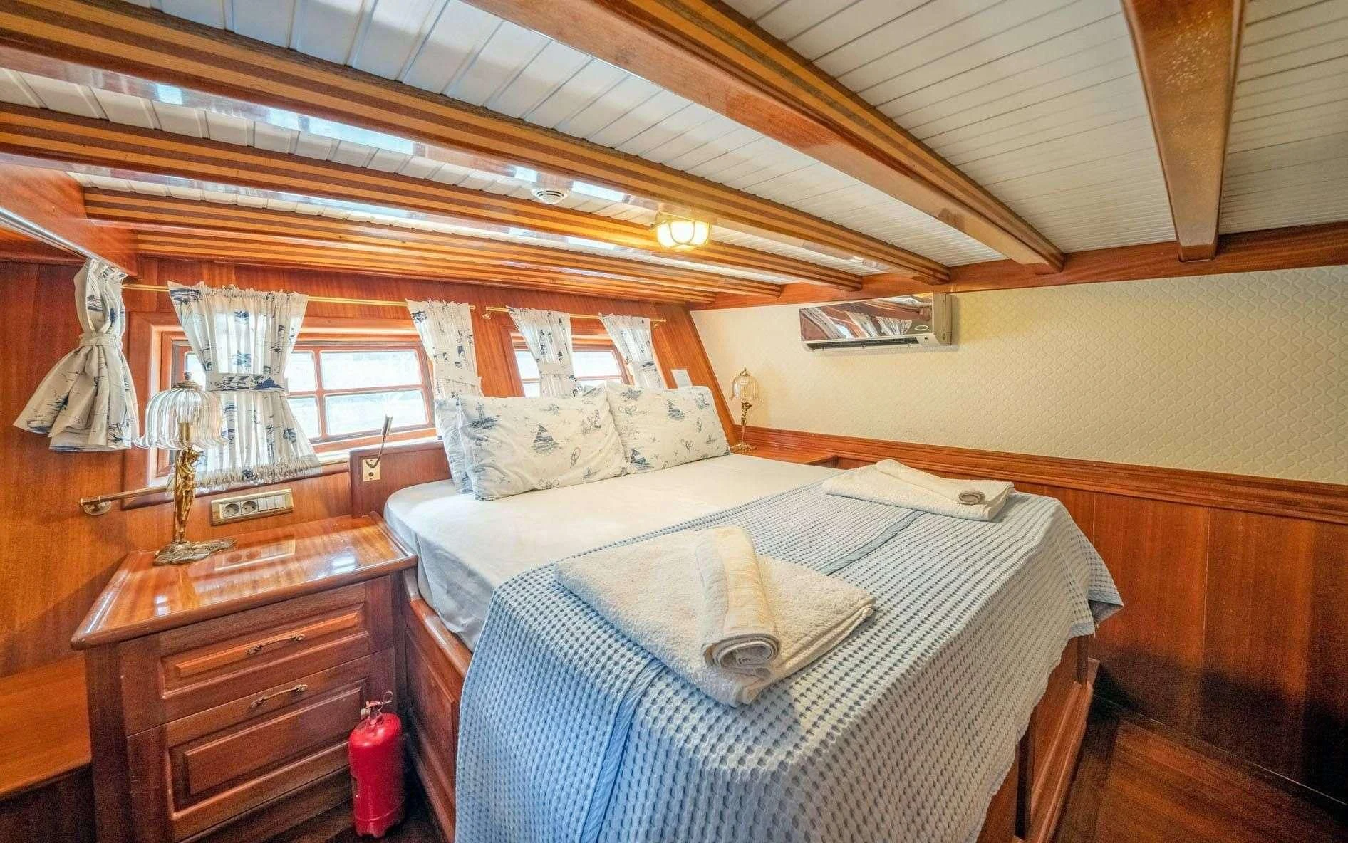 a bedroom with a bed and a dresser aboard ADMIRAL Yacht for Charter