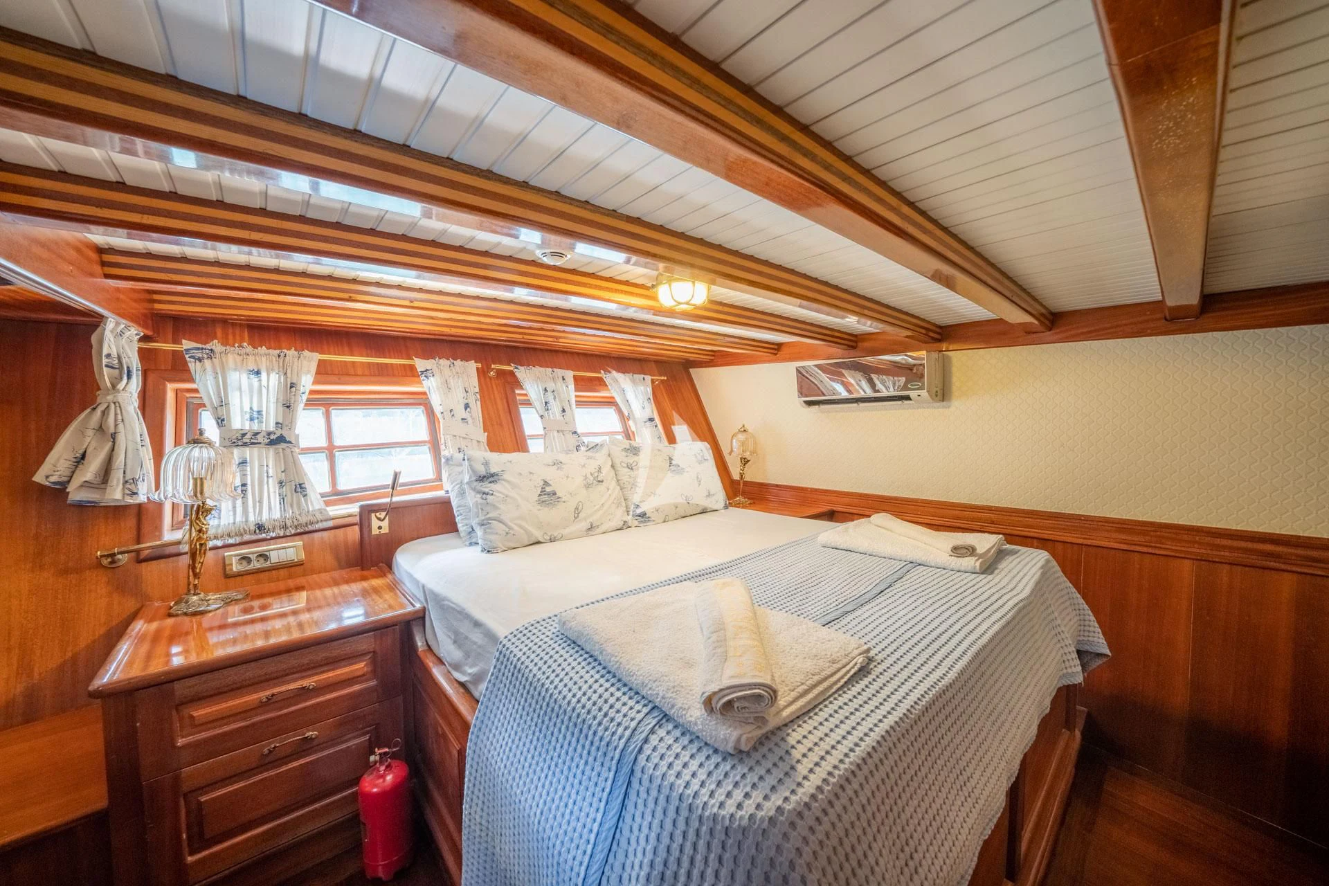 a bed with a white sheet and a wooden headboard aboard ADMIRAL Yacht for Charter