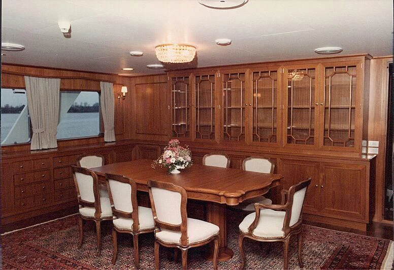 a room with a table chairs and cabinets aboard ORION Yacht for Sale