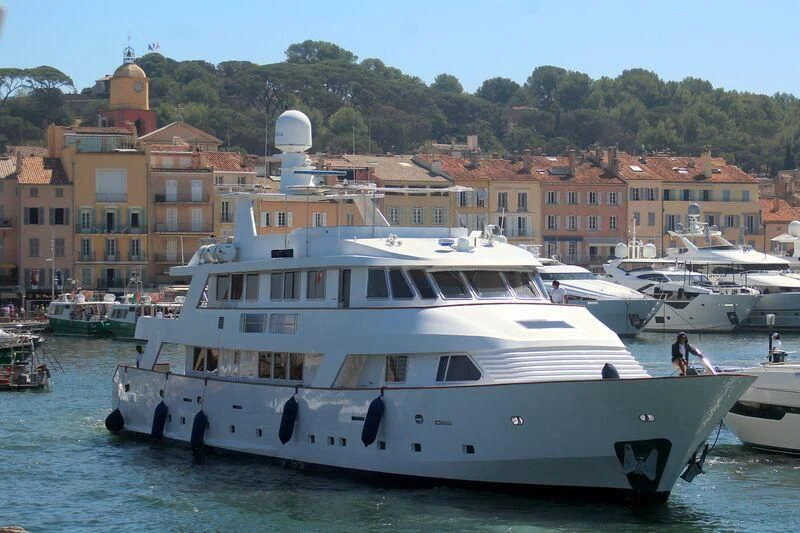 a large white boat in a harbor aboard SUPERMAX Yacht for Sale