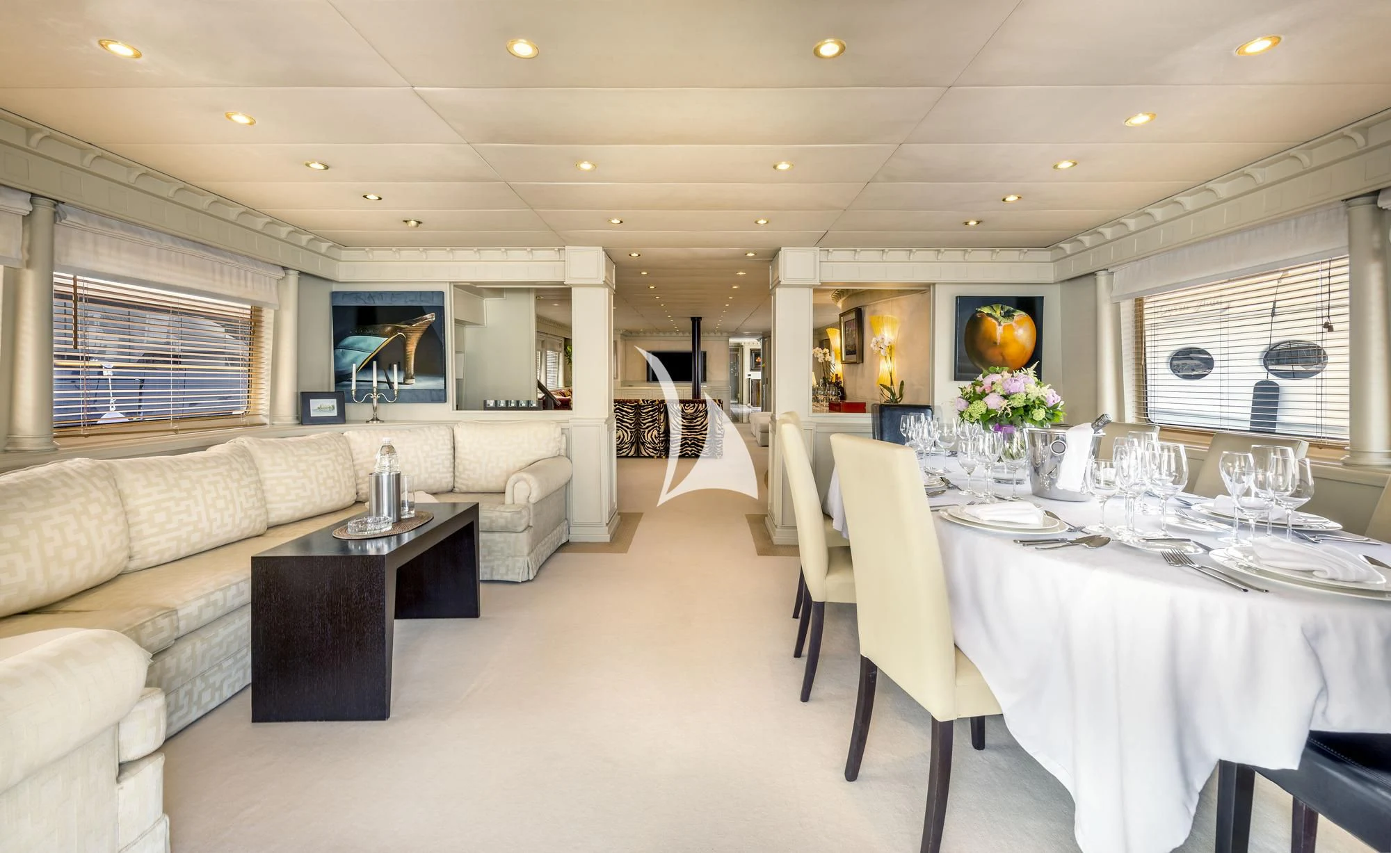 a large living room with a white table and chairs aboard SUPERMAX Yacht for Sale