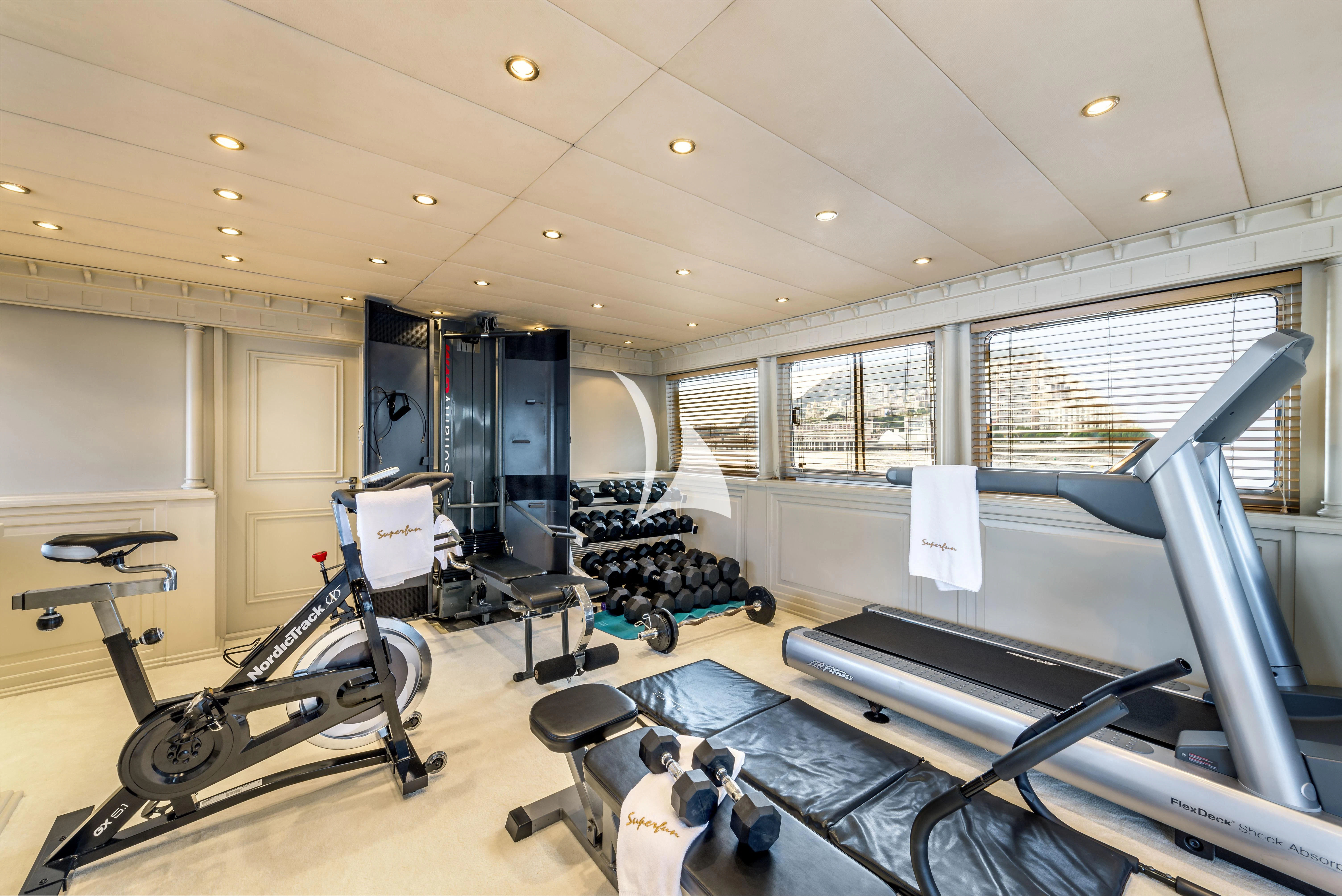 a room with a gym and exercise equipment aboard SUPERMAX Yacht for Sale