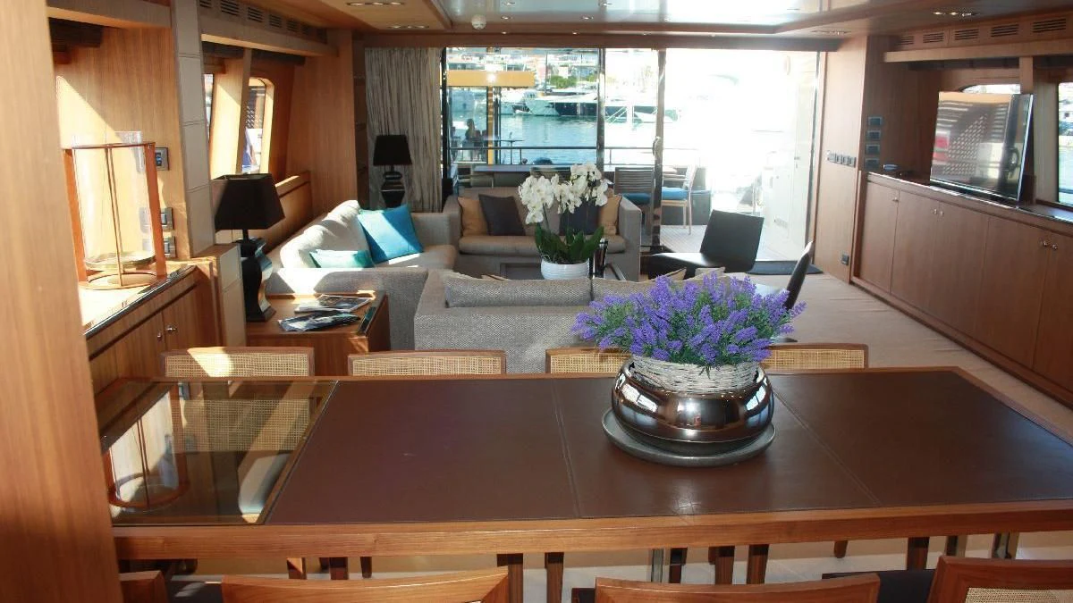 a living room with a table and couches aboard TAURUS Yacht for Sale