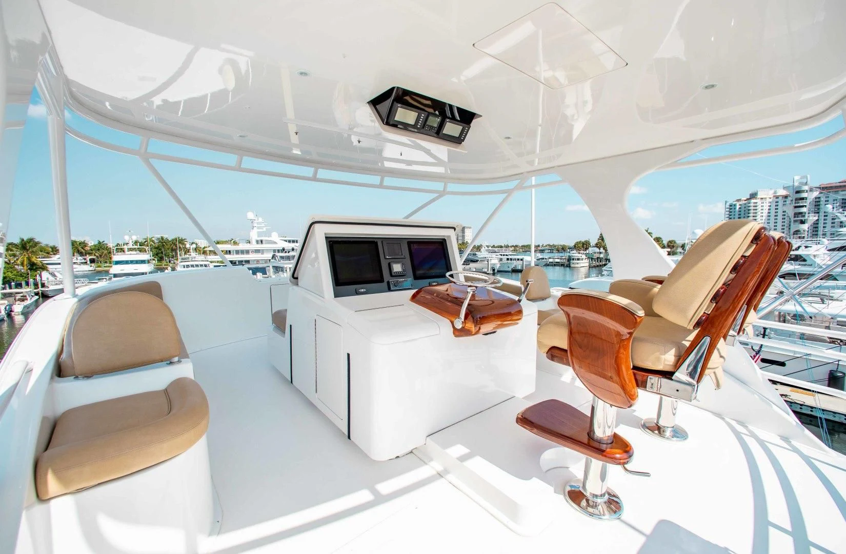 a room with a large white tent and a table with chairs and a television on it aboard BIMINI BABE Yacht for Sale