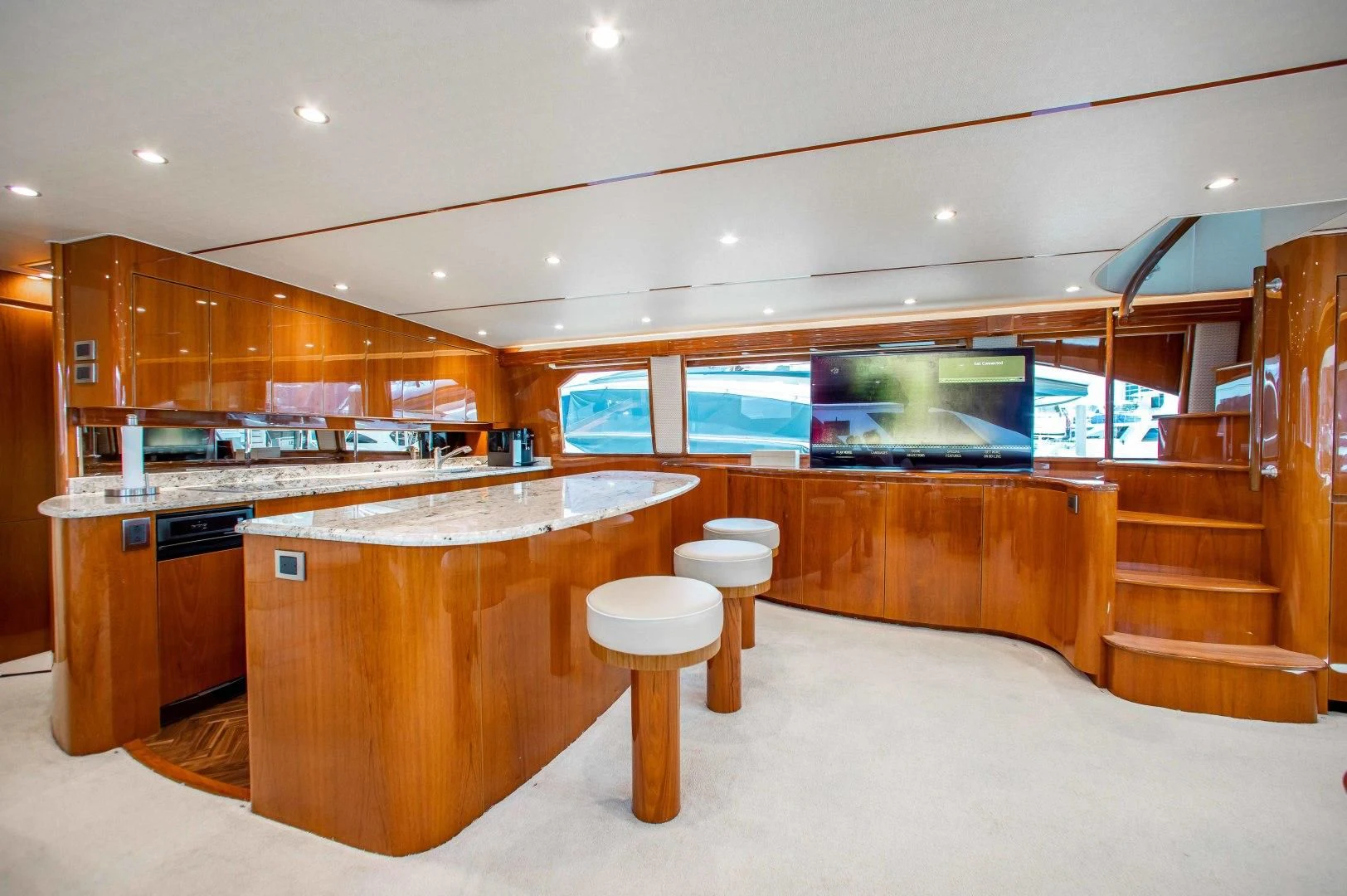 a large kitchen with a bar and a staircase aboard BIMINI BABE Yacht for Sale