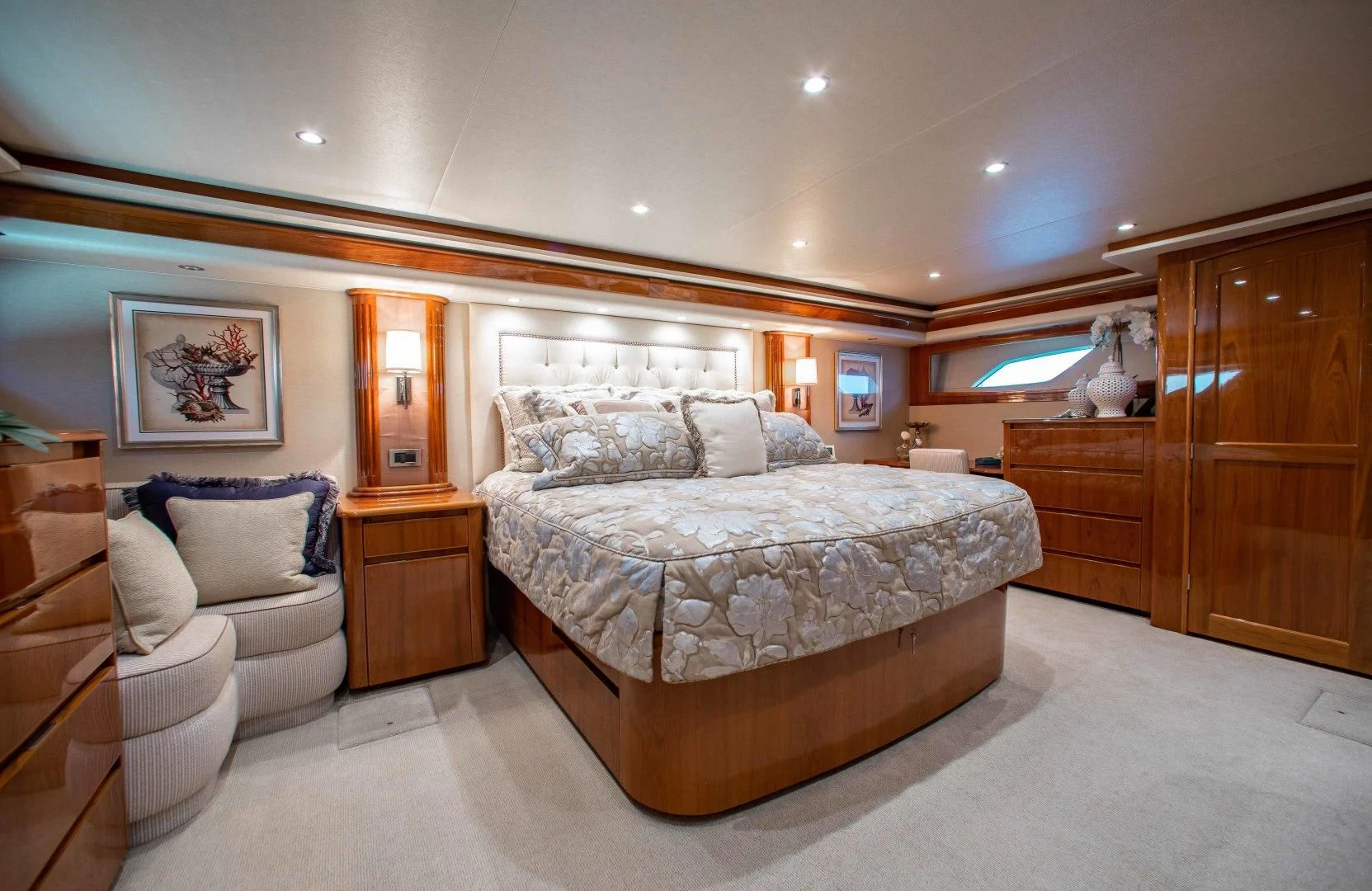 a large bedroom with a bed and a chair aboard BIMINI BABE Yacht for Sale