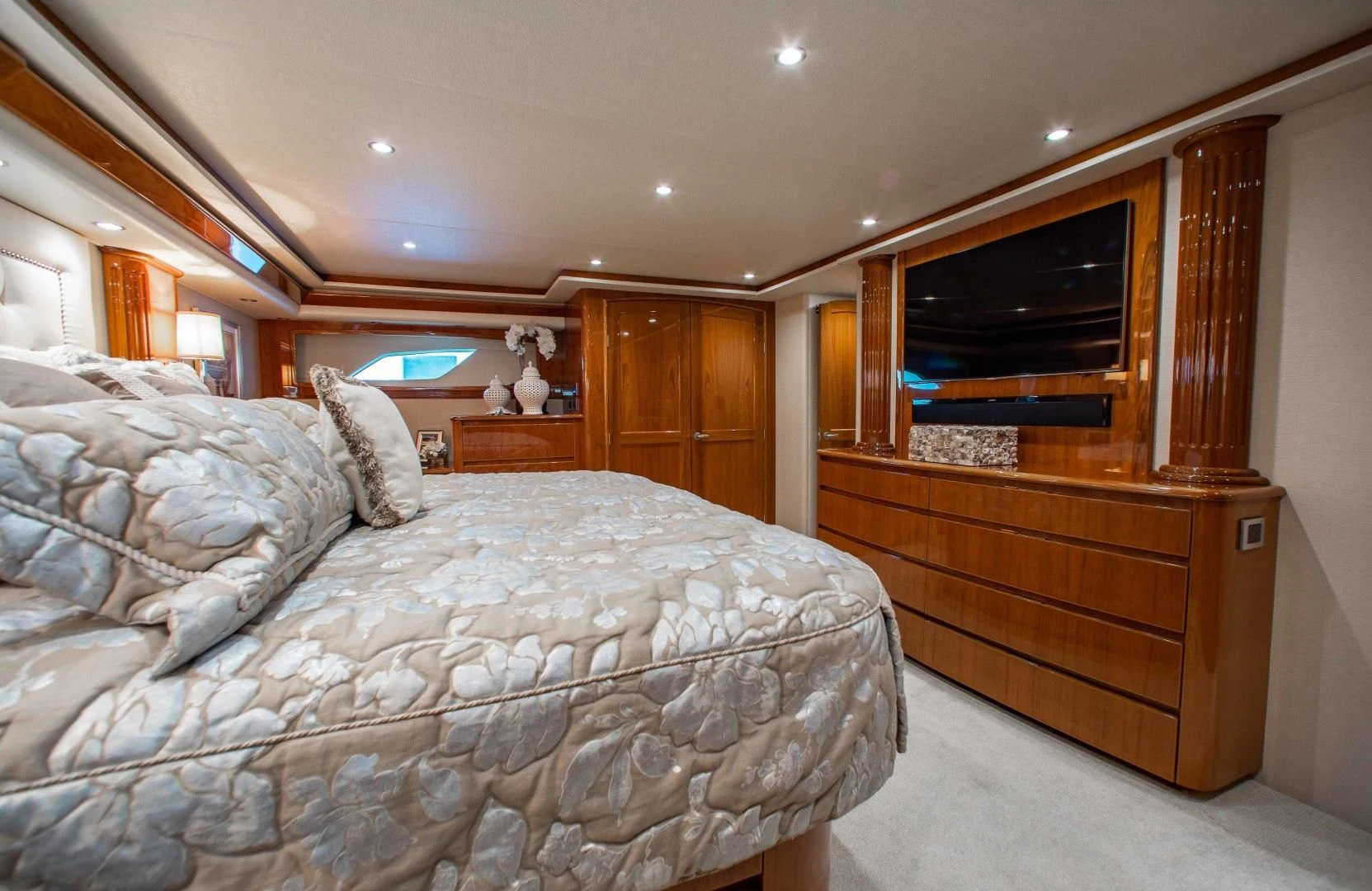 a bedroom with a bed and a television aboard BIMINI BABE Yacht for Sale