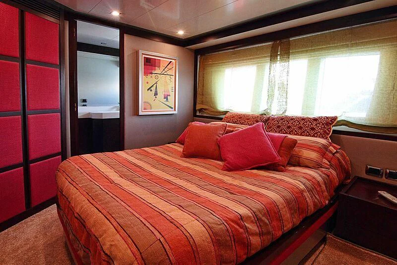a bed with red pillows aboard GEMINIS Yacht for Sale