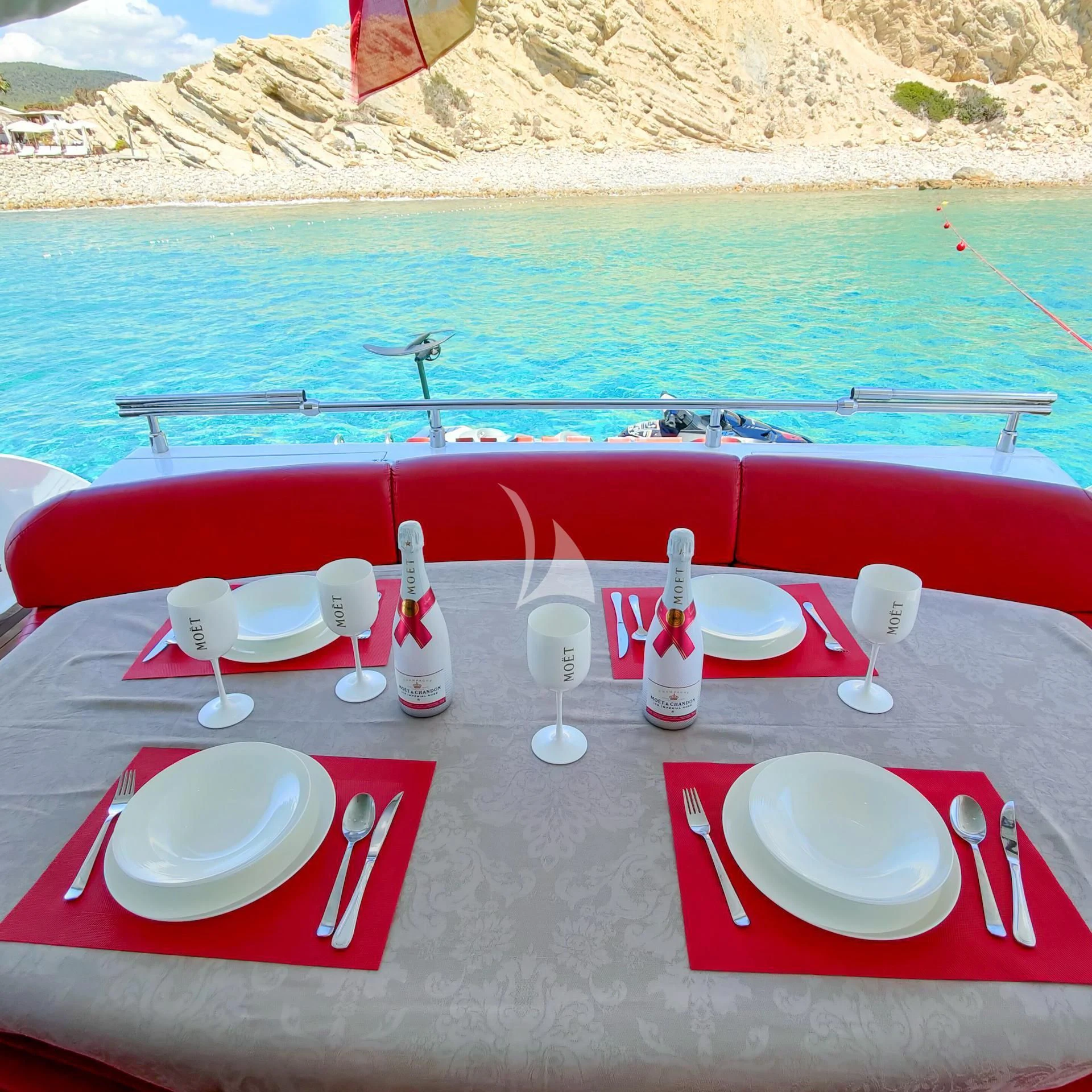 a table with plates and chairs on it by a body of water aboard GEMINIS Yacht for Sale