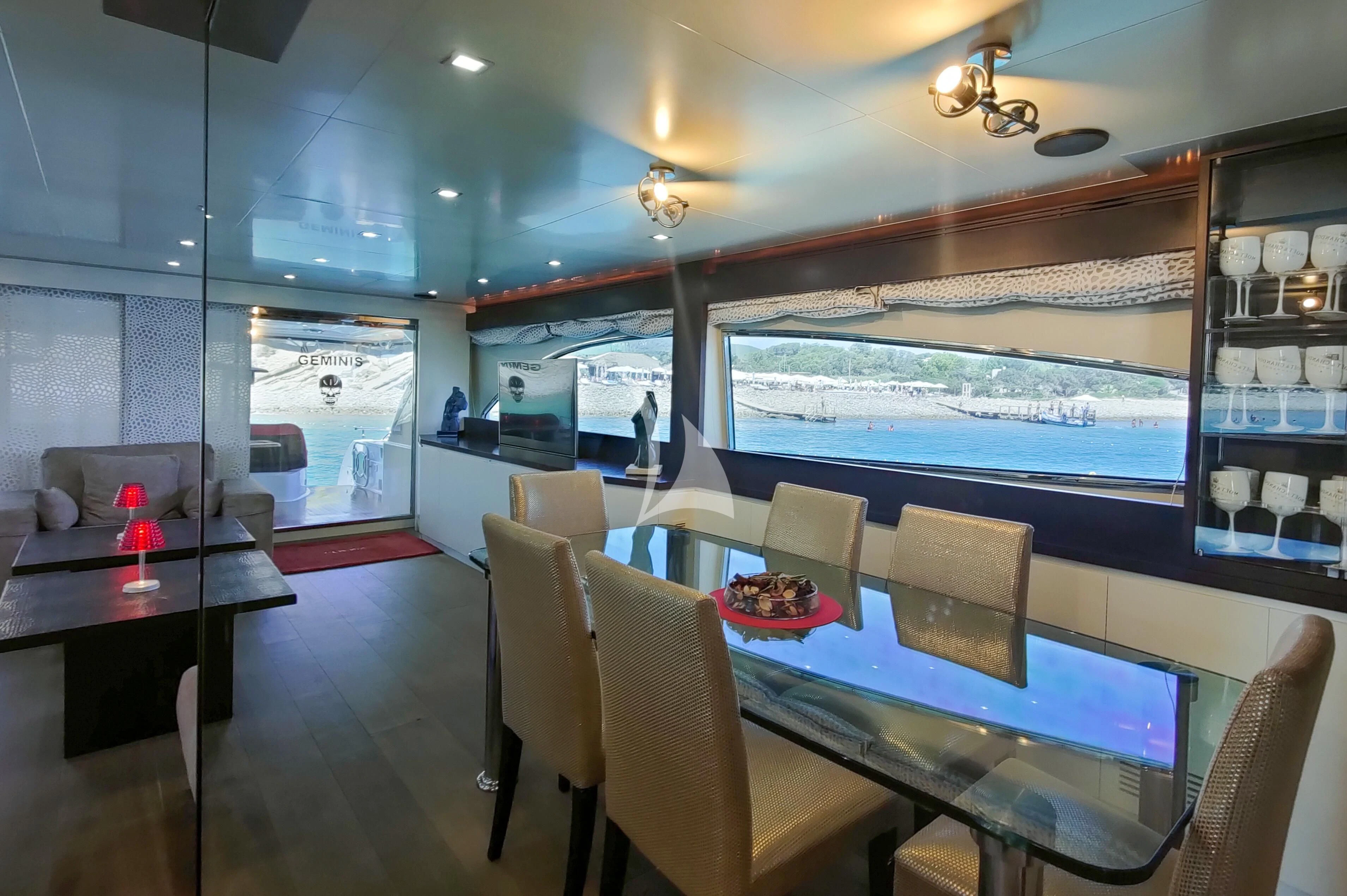 a room with a table chairs and a glass wall aboard GEMINIS Yacht for Sale