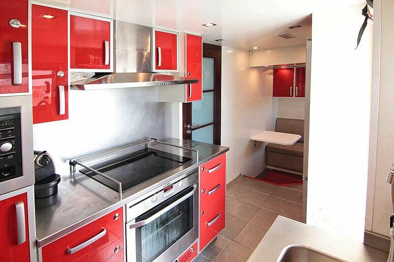 a kitchen with red cabinets aboard GEMINIS Yacht for Sale
