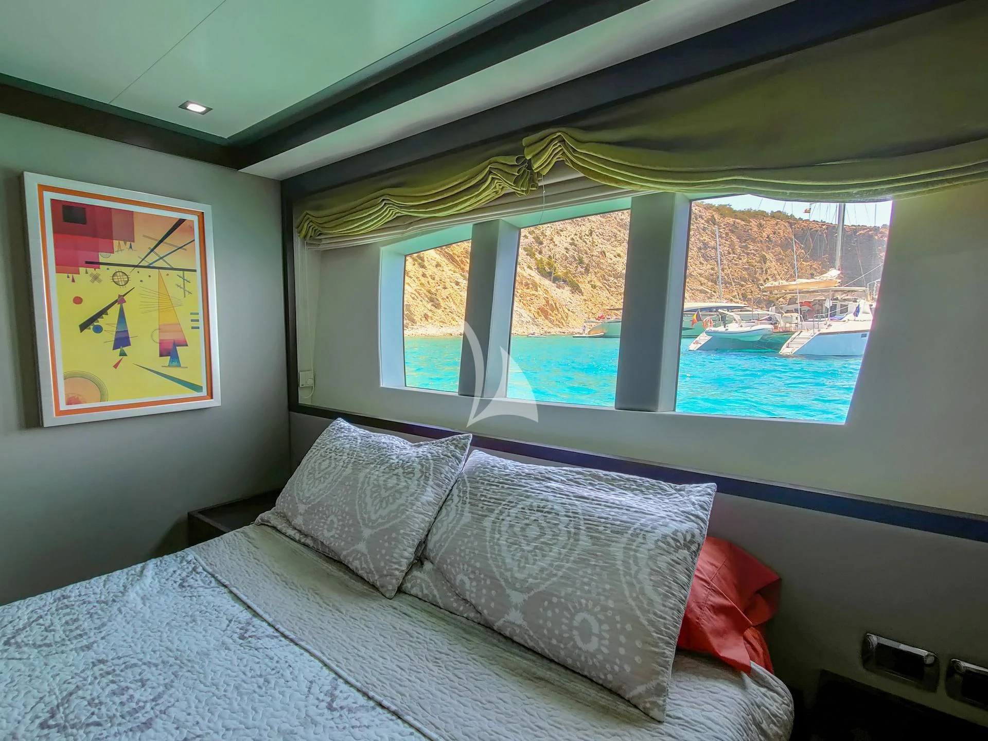 a bed with a painting on the wall aboard GEMINIS Yacht for Sale