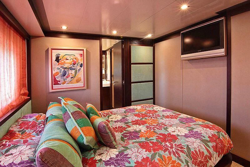 a bed with a colorful comforter aboard GEMINIS Yacht for Sale