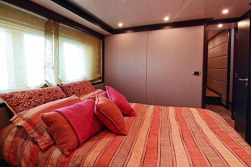 a bed with red pillows aboard GEMINIS Yacht for Sale