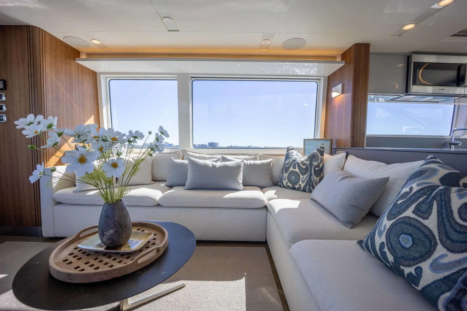 a living room with a white couch and a table with flowers aboard MY 3 GALS Yacht for Sale