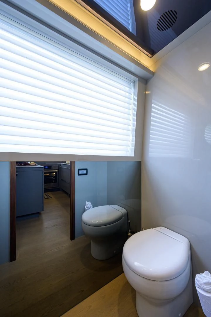 a bathroom with a toilet and a window aboard MY 3 GALS Yacht for Sale