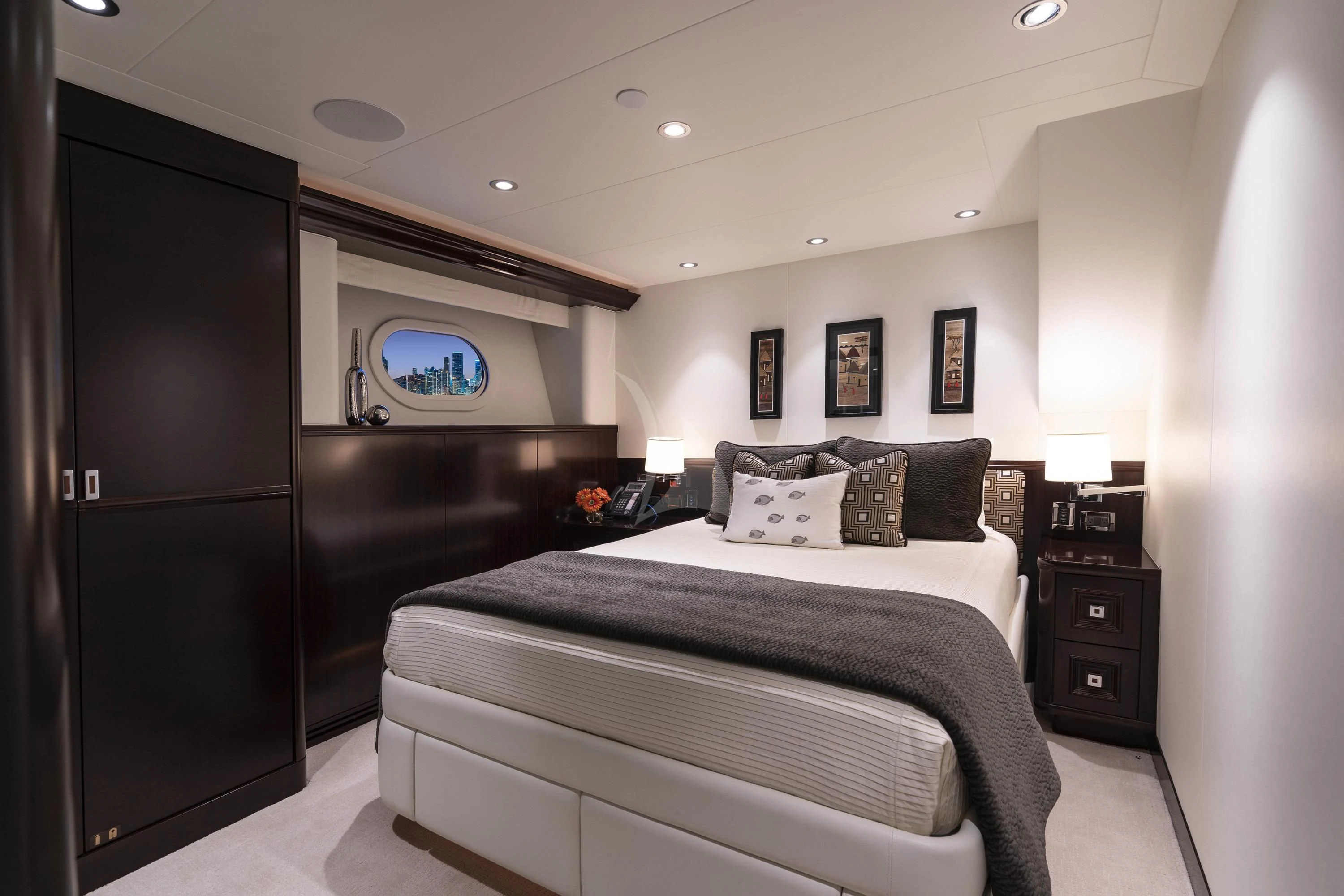 a bedroom with a bed and a dresser aboard DRILLER Yacht for Sale