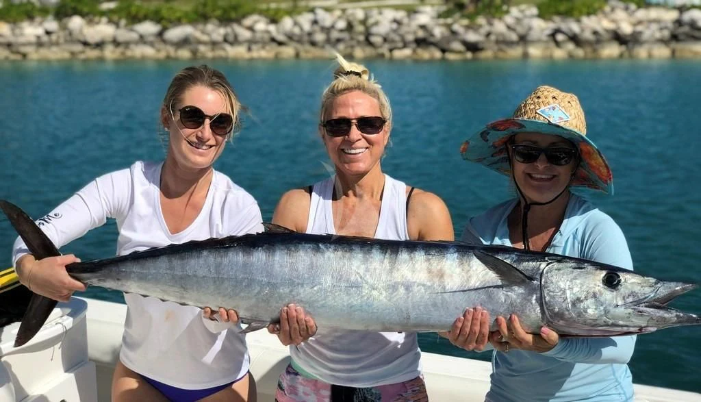 a group of people holding a fish aboard DRILLER Yacht for Sale
