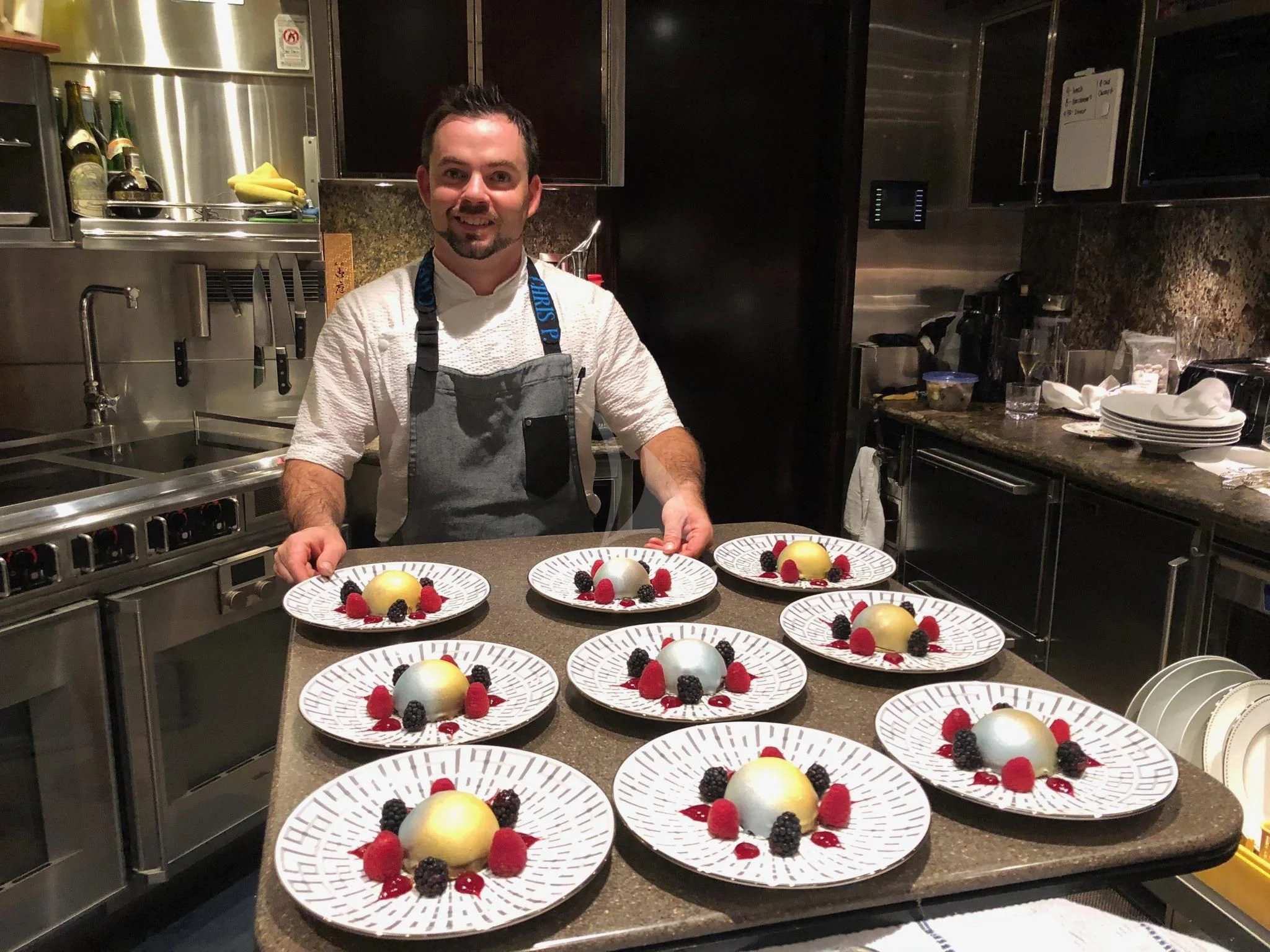 a chef standing behind a counter full of food aboard DRILLER Yacht for Sale
