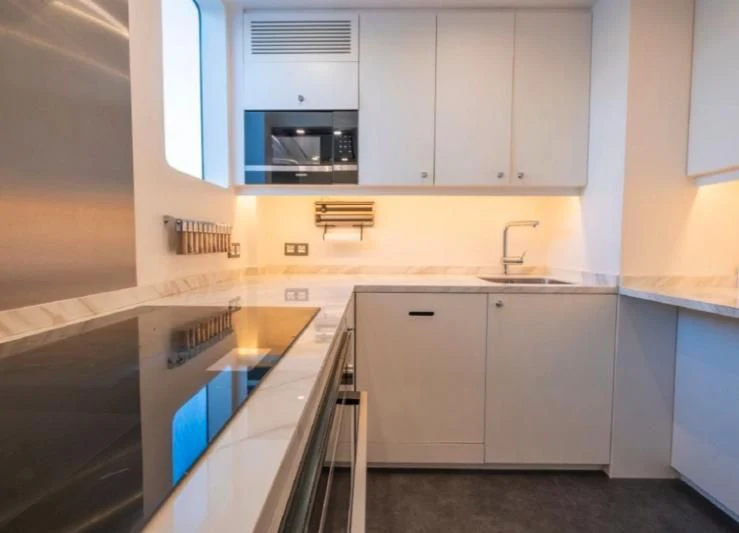 a kitchen with white cabinets aboard MURAL YACHTS 85 TRAWLER Yacht for Sale