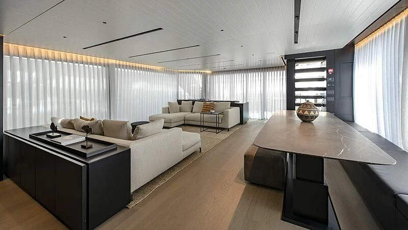 a living room with a large table and couches aboard AMWAJ Yacht for Sale
