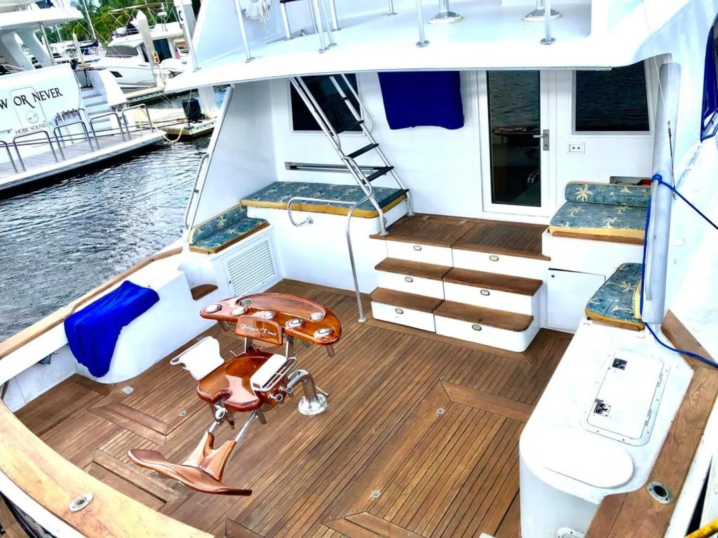 a room with a wood floor and a wood floor with a white table and chairs and a large aboard PRIME TIME Yacht for Sale