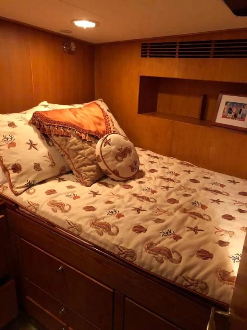 a bed with a blanket on it aboard PRIME TIME Yacht for Sale