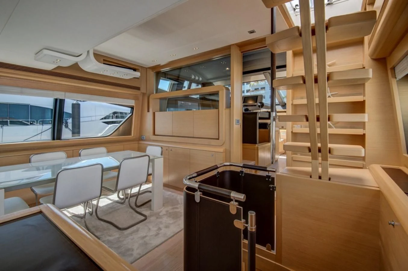 a room with a wood staircase and a table and chairs aboard GOLDEN BELLE Yacht for Sale