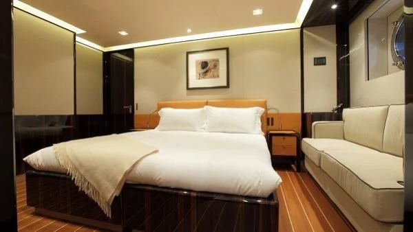 a room with a bed and a couch aboard SERENDIPITY I Yacht for Charter