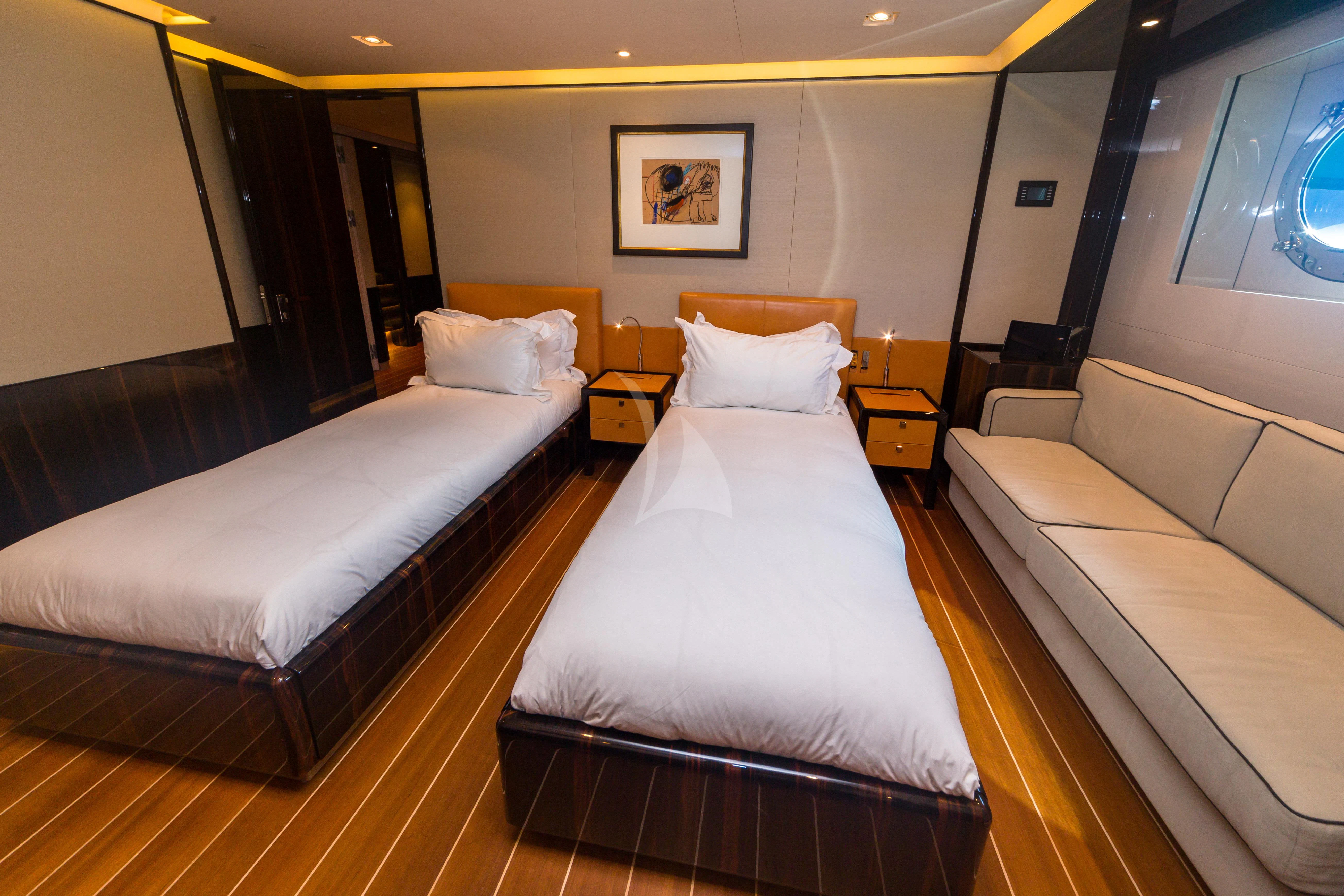 a room with beds and a couch aboard SERENDIPITY I Yacht for Charter