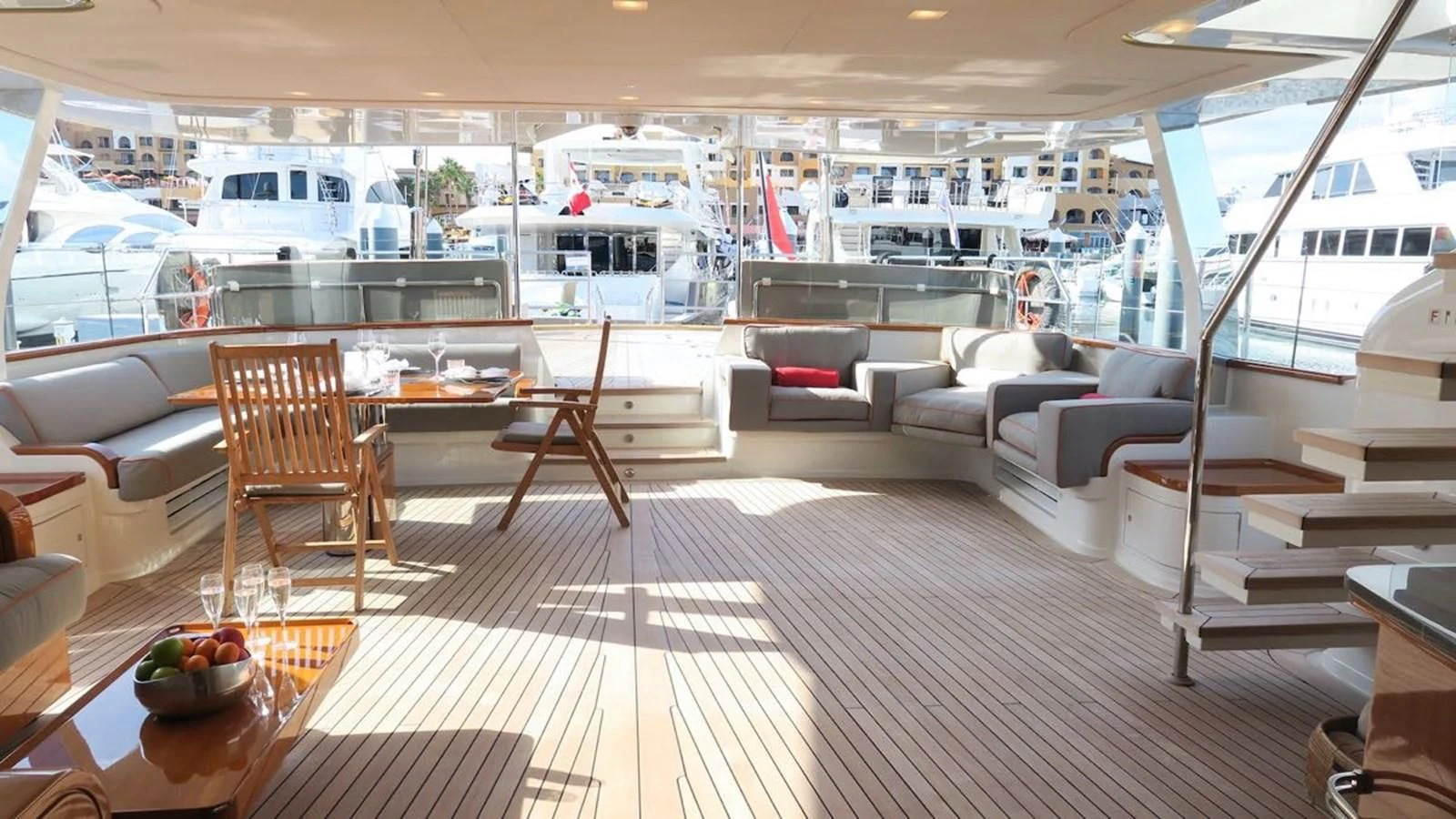 a room with a table chairs and a boat in the background aboard SERENDIPITY I Yacht for Charter