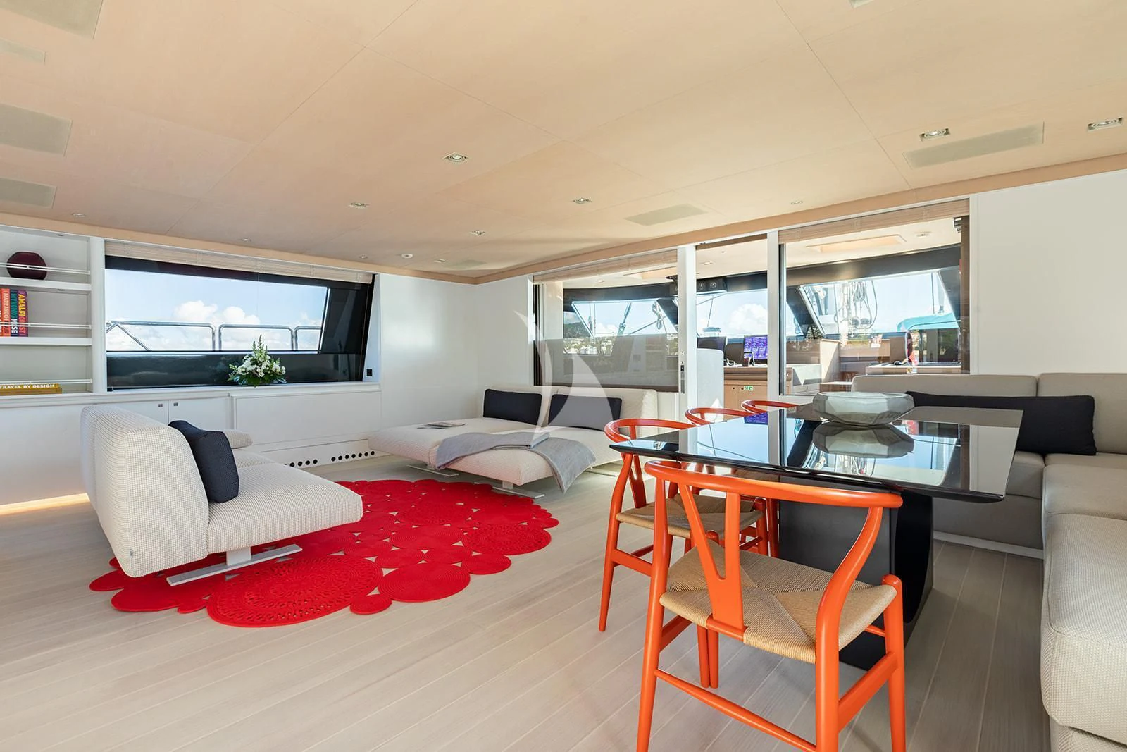 a living room with a red couch and a table aboard SERENDIPITY I Yacht for Charter