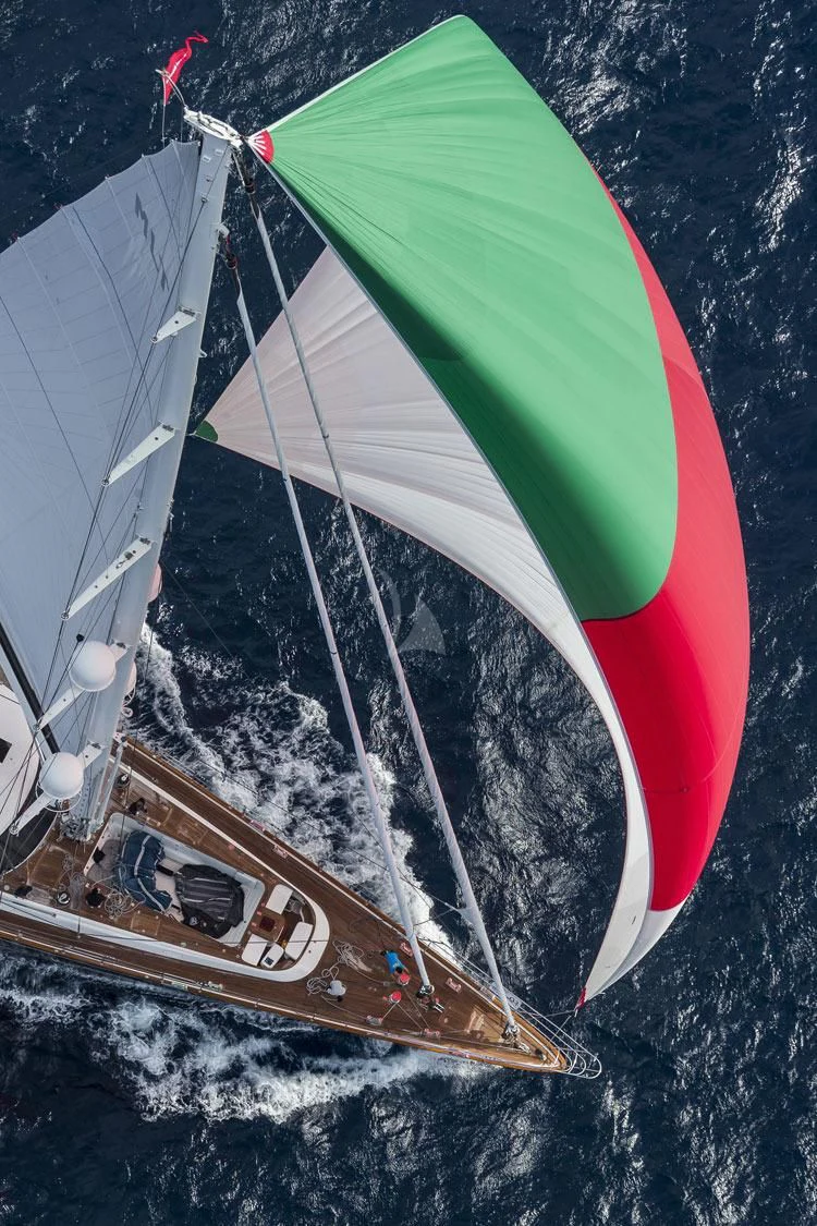 a sailboat with a red and green sail aboard SERENDIPITY I Yacht for Charter