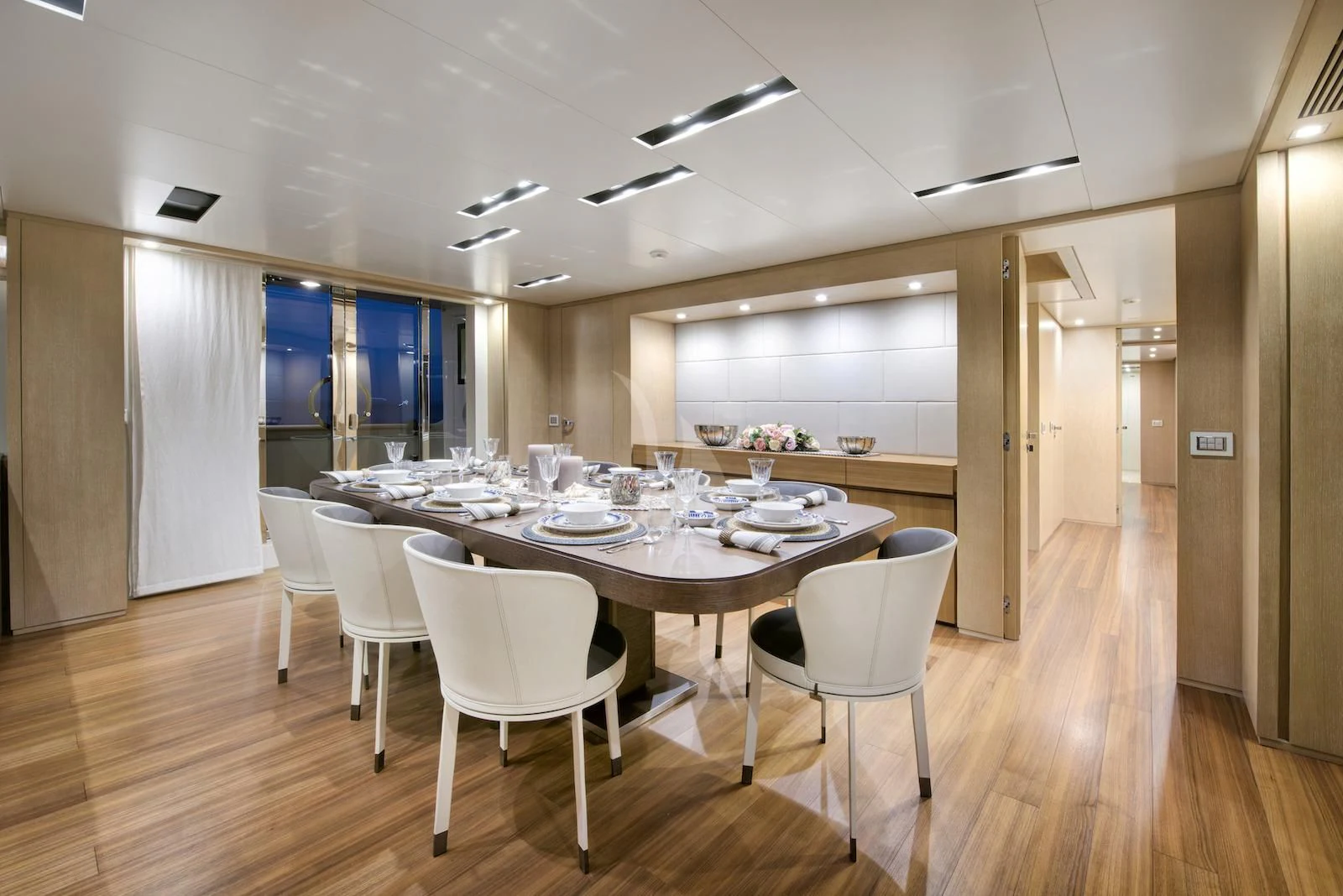 a large dining room with white chairs aboard THERAPY Yacht for Sale