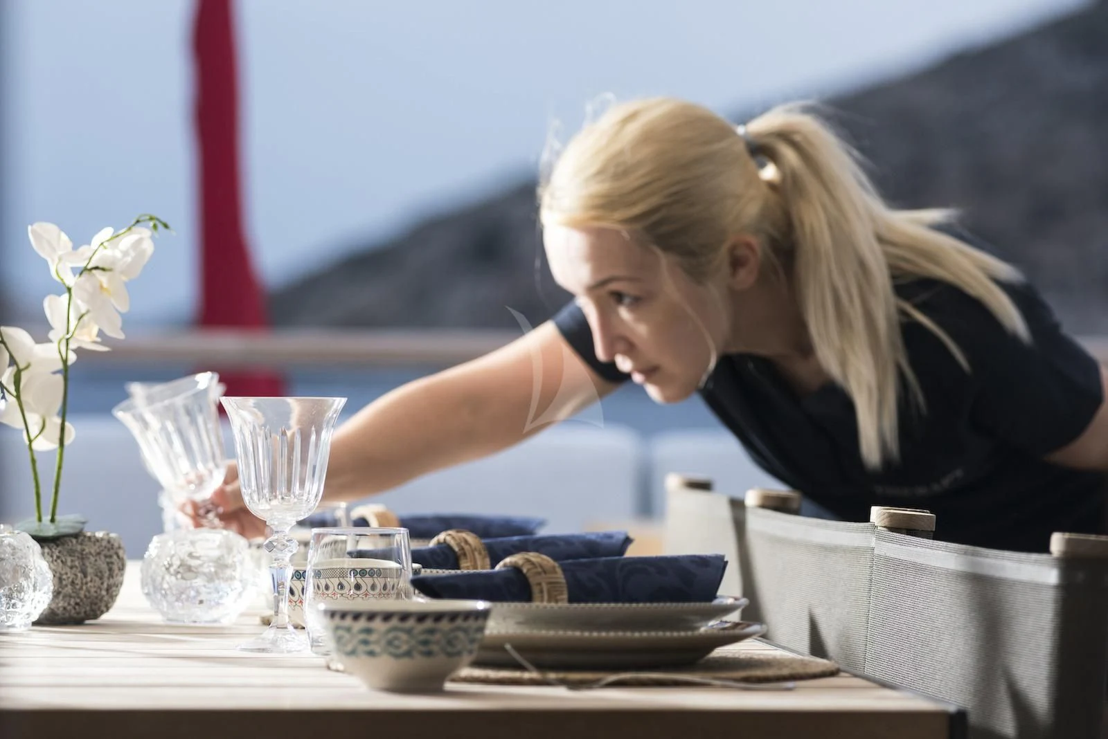 a woman looking at a glass of water aboard THERAPY Yacht for Sale
