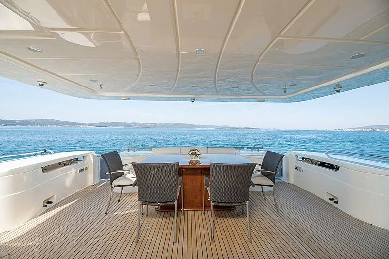 a table and chairs on a deck aboard NEOSTAR Yacht for Sale