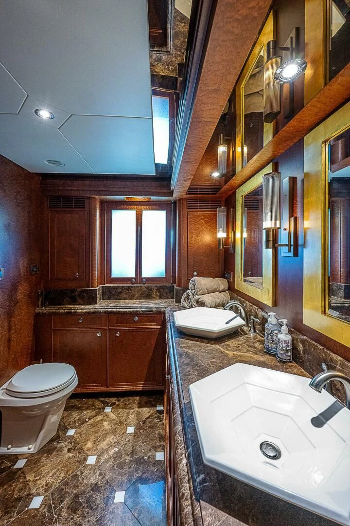 a bathroom with a sink toilet and a mirror aboard PREDATOR I Yacht for Sale