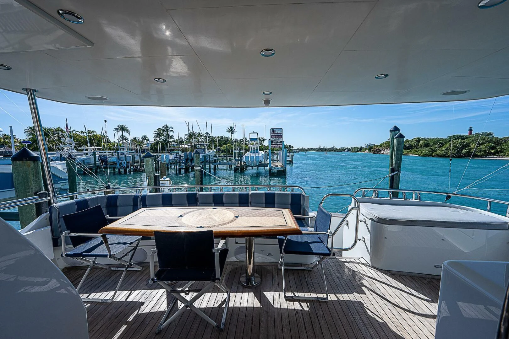 a table and chairs on a deck overlooking a body of water aboard PREDATOR I Yacht for Sale