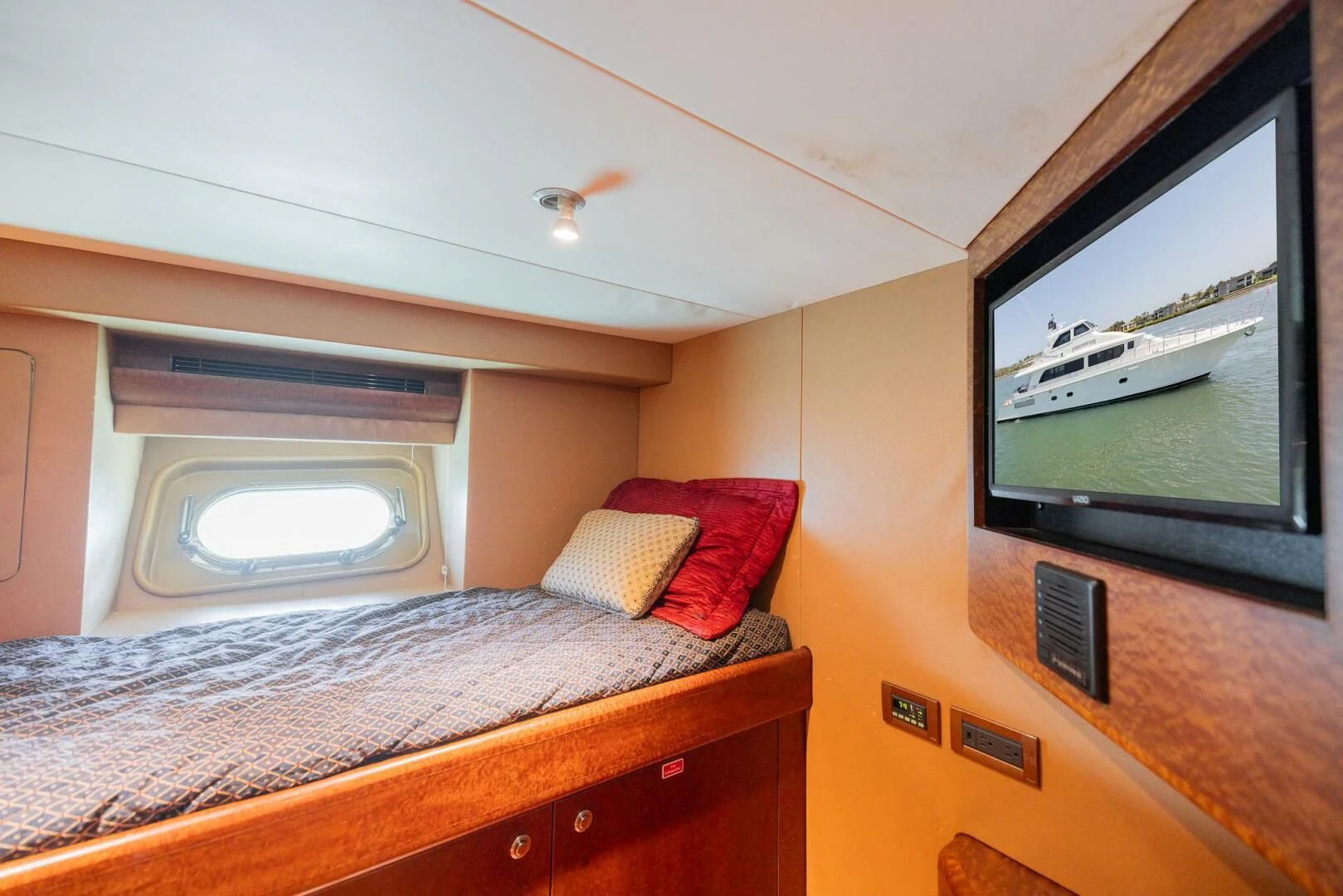 a bed with a television on the wall aboard PREDATOR I Yacht for Sale