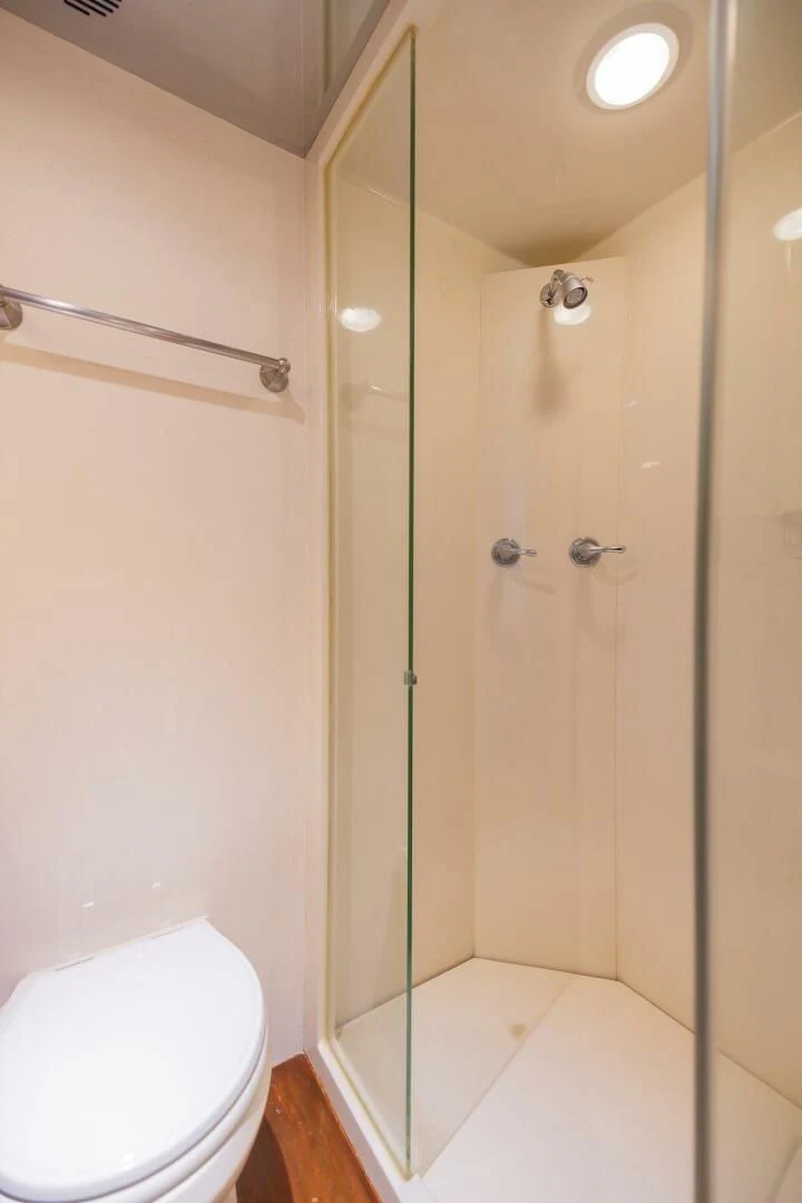 a bathroom with a glass shower door aboard PREDATOR I Yacht for Sale
