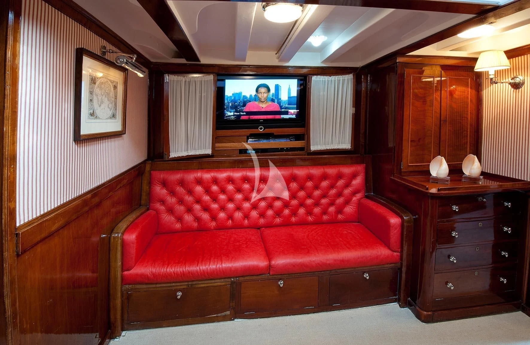 a red couch in a living room aboard ORIANDA Yacht for Charter