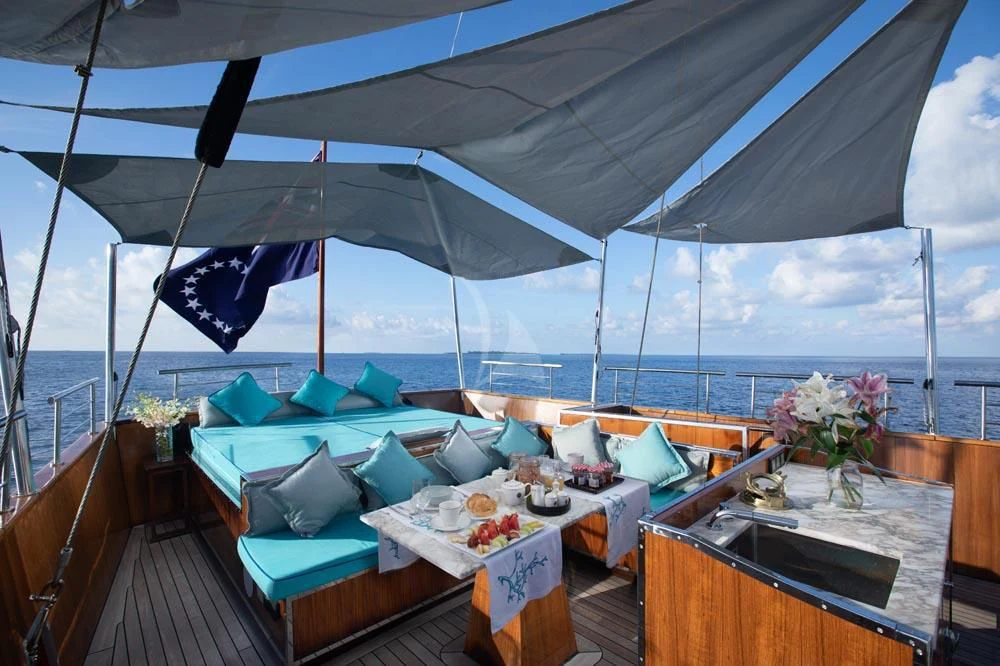 a table set for a meal on a deck overlooking the ocean aboard KALIZMA Yacht for Sale