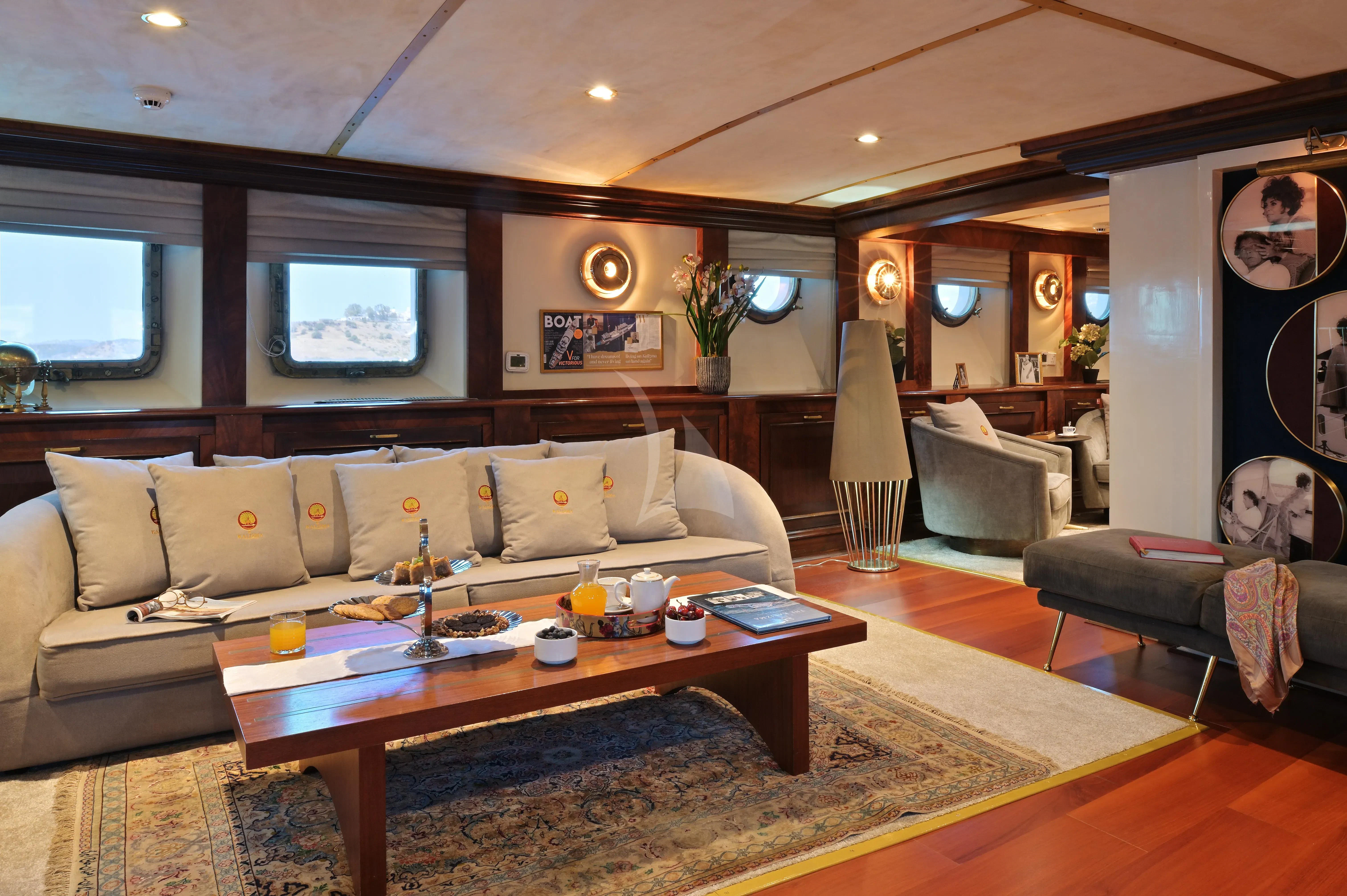a living room with a large coffee table and a large window aboard KALIZMA Yacht for Sale