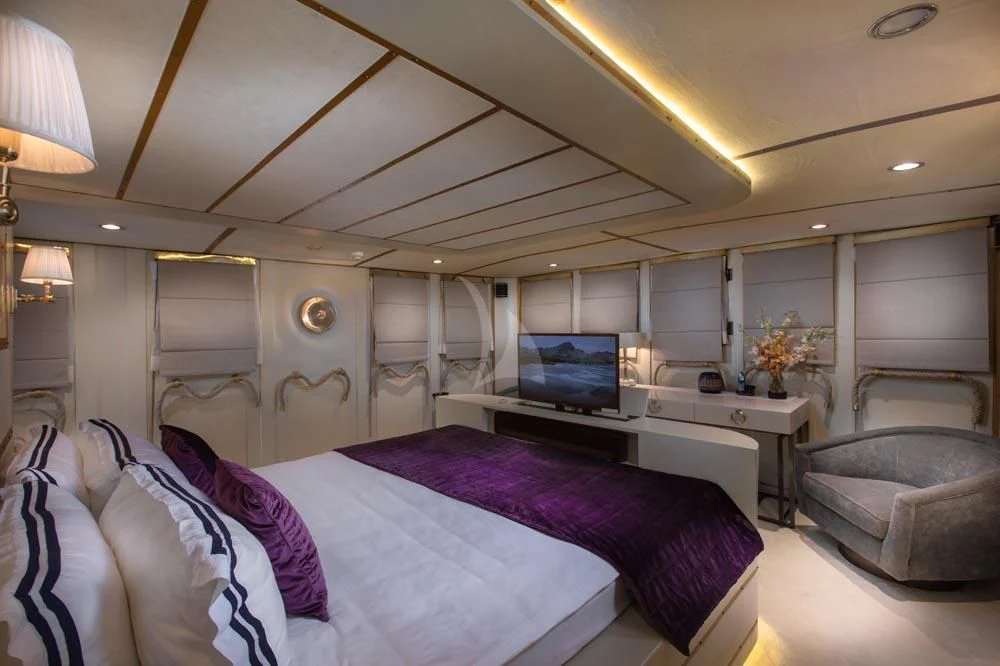 a bedroom with a bed and a desk aboard KALIZMA Yacht for Sale