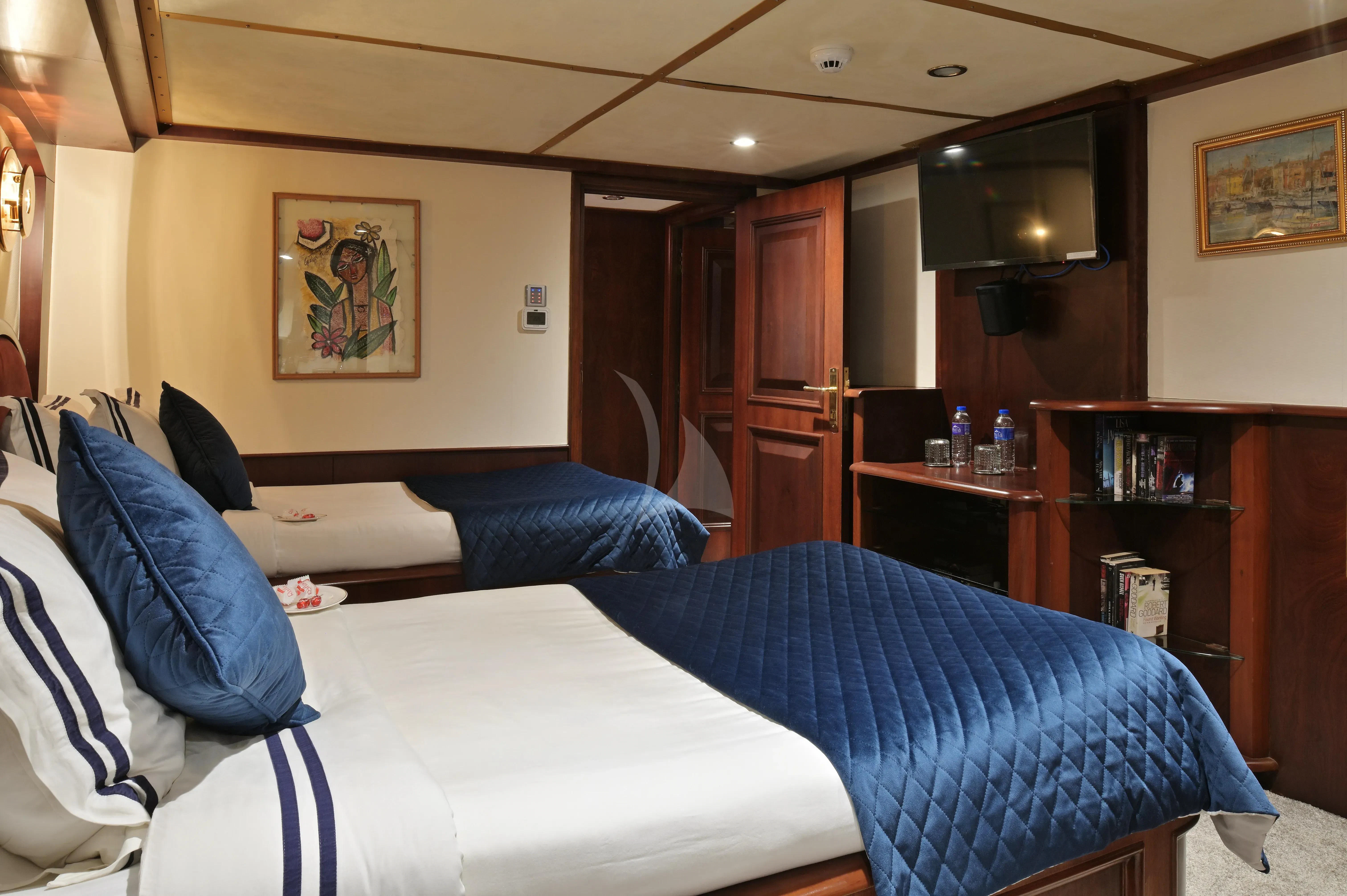 a bedroom with a bed and a television aboard KALIZMA Yacht for Sale