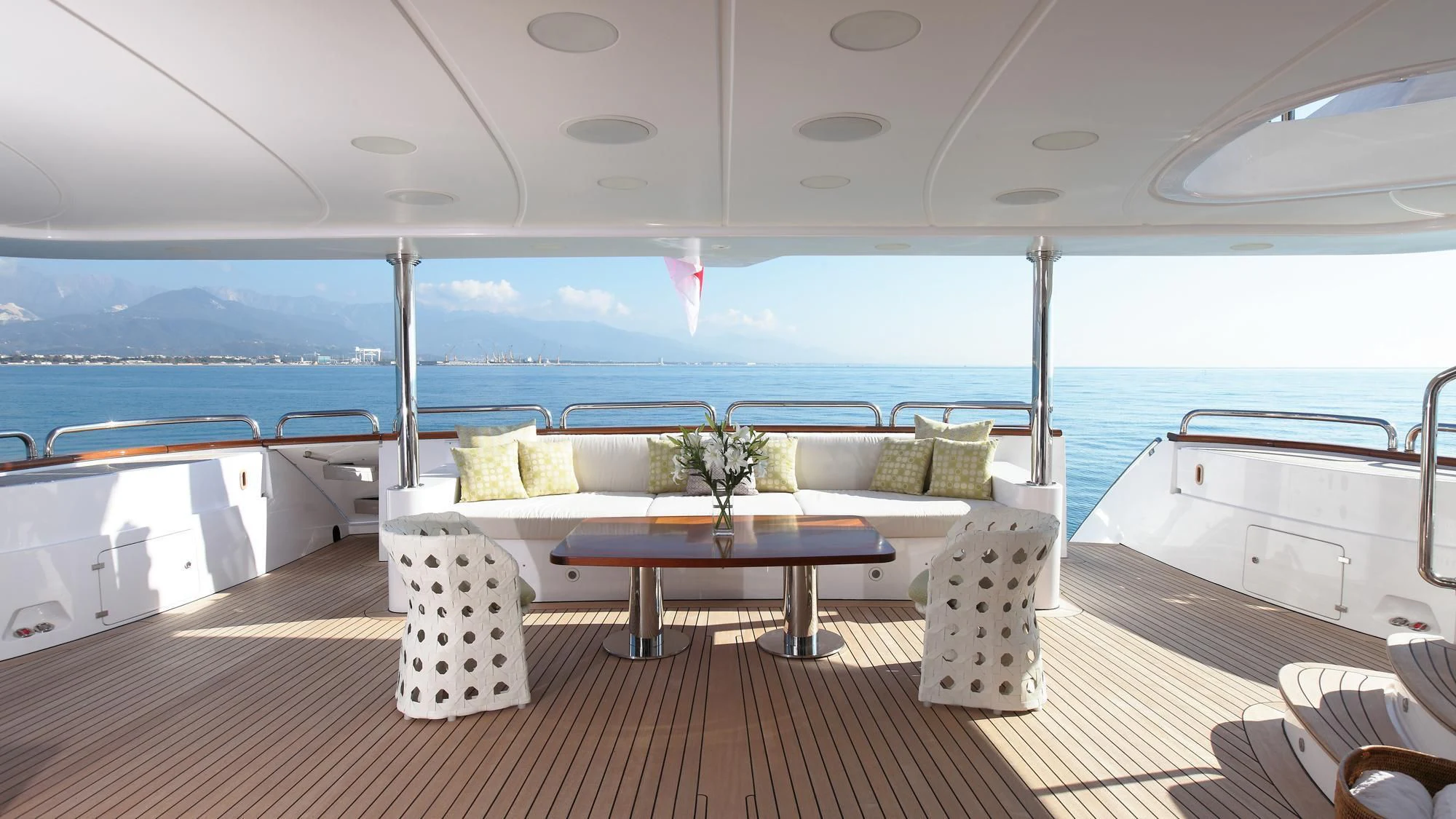 a large white lounge chair on a deck overlooking a large body of water aboard LATIKO Yacht for Charter