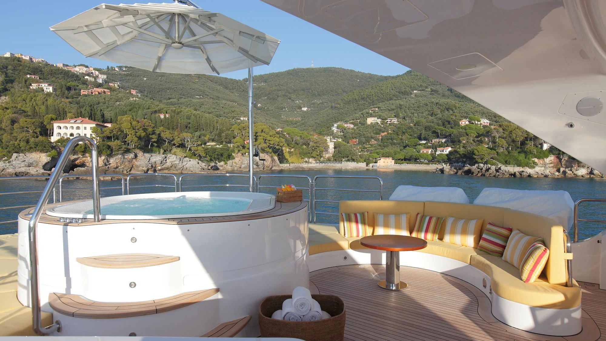 a room with a pool and a deck with a view of a mountain range aboard LATIKO Yacht for Charter