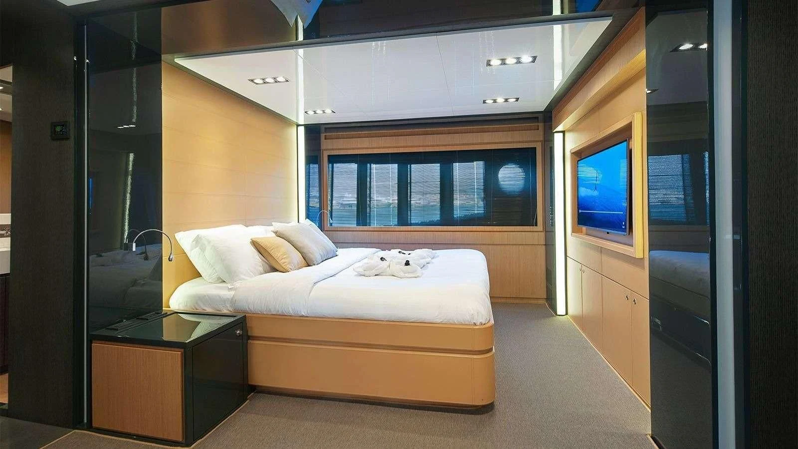 a room with a bed and a tv aboard WHATEVER Yacht for Charter
